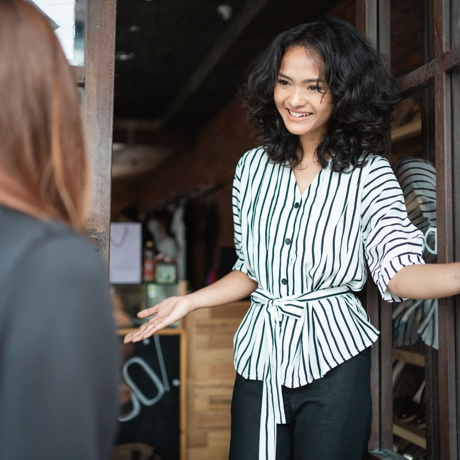 Smiling woman engaging in conversation at Foundation for Intentional Community event.