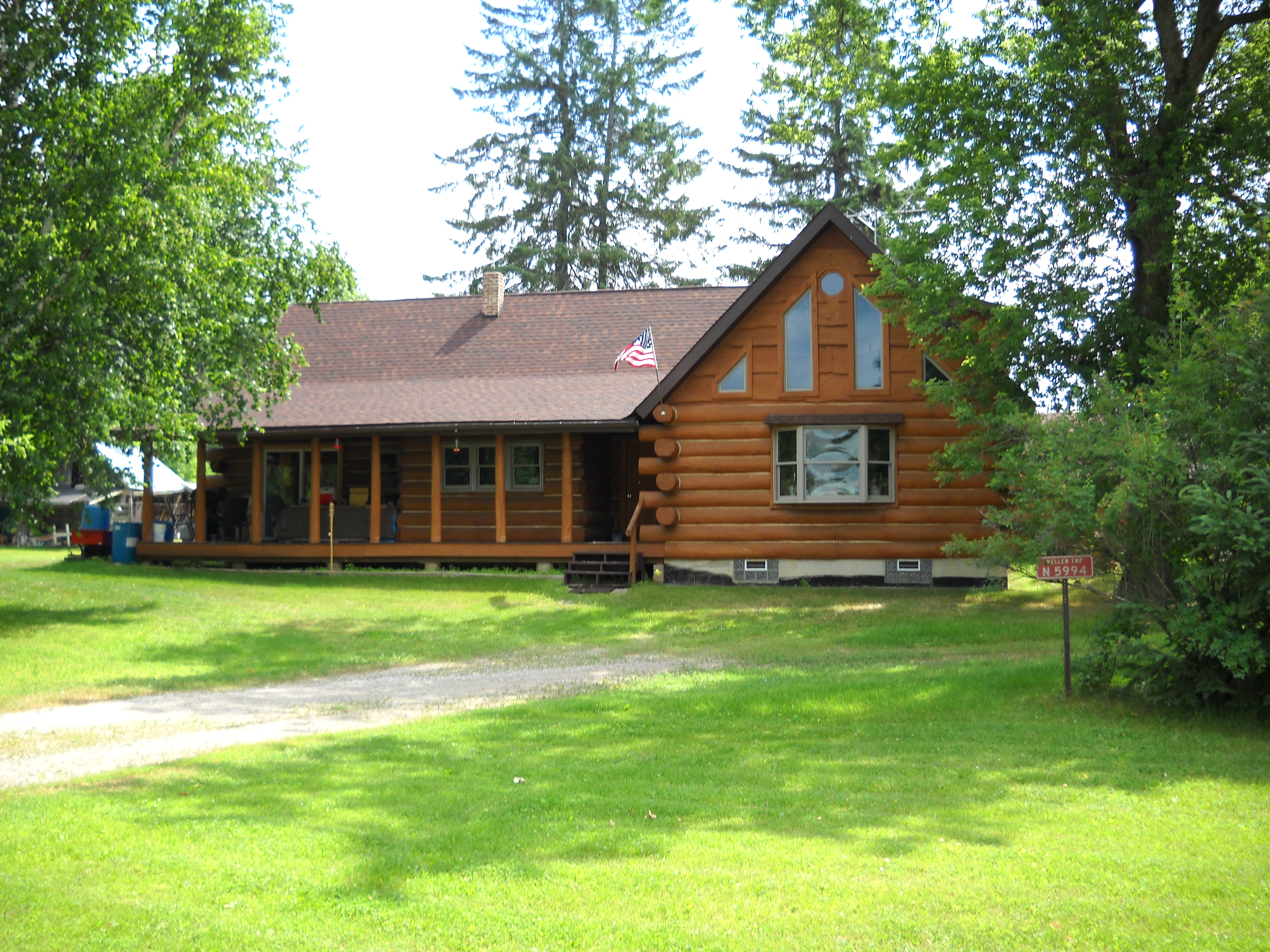 Log cabin surrounded by trees at ONE Homestead Intentional Community.