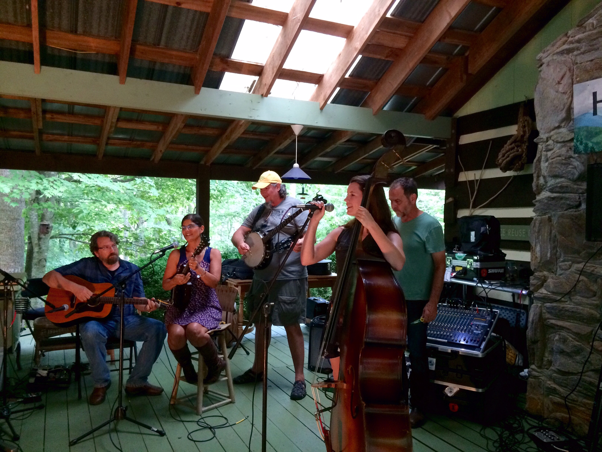 Group of musicians playing instruments at a community gathering in a rustic setting.