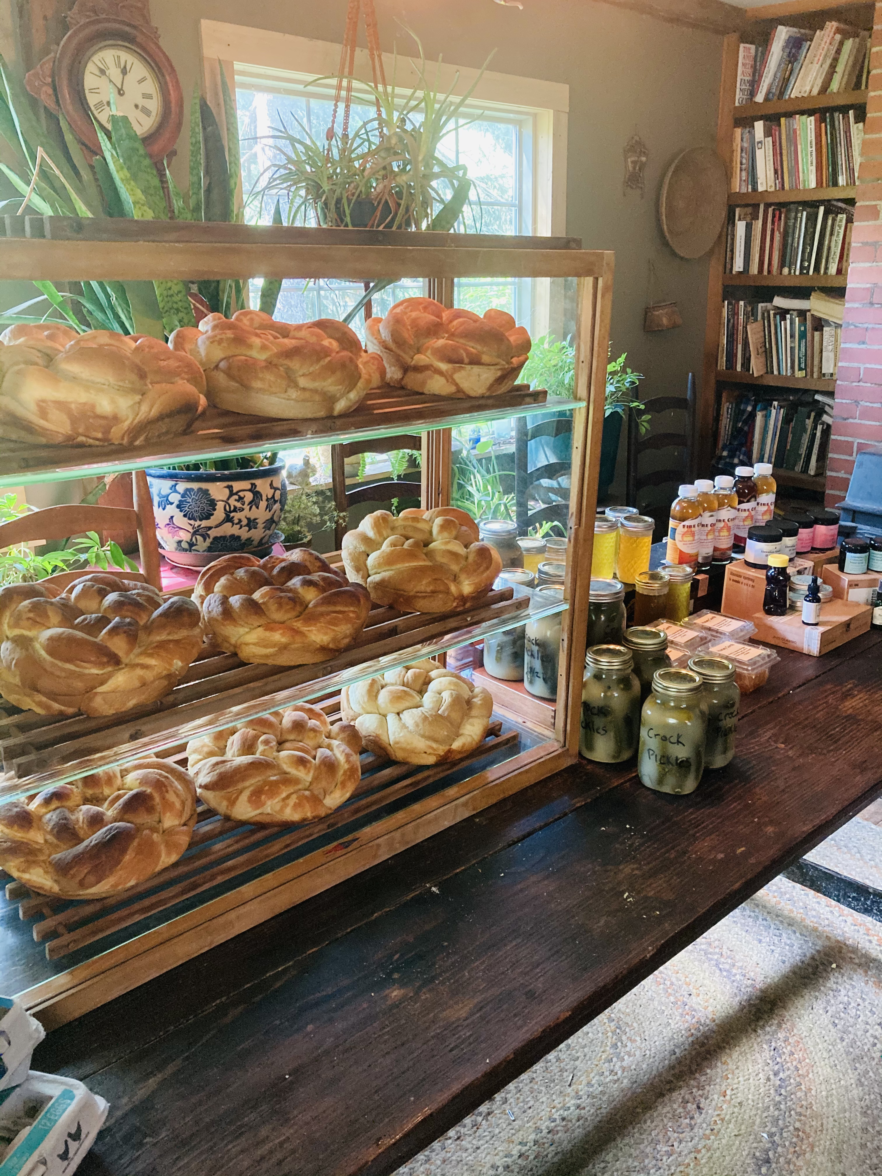 Display of freshly baked bread and jars of honey at community market.