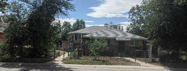 Residential house in Dry Gulch Ecovillage with trees and garden.