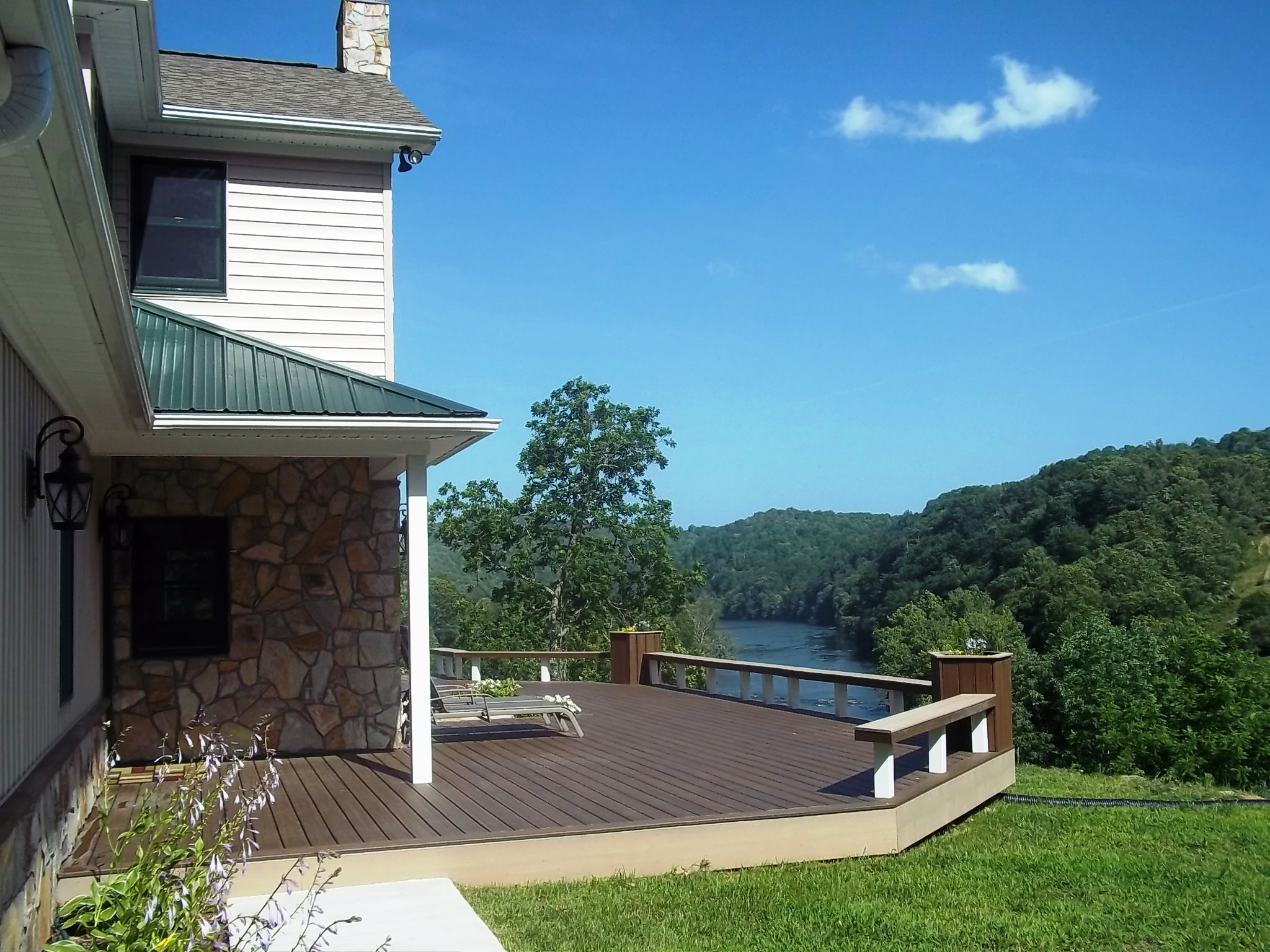 Scenic community deck overlooking lush green valley and river.