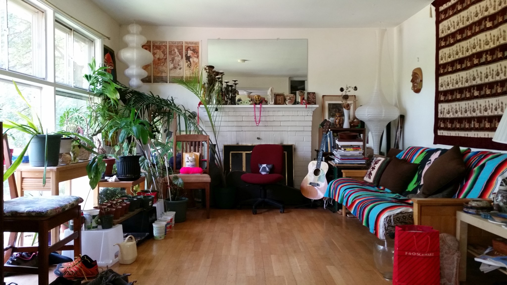 Bright living room with plants, colorful sofa, and musical instruments.