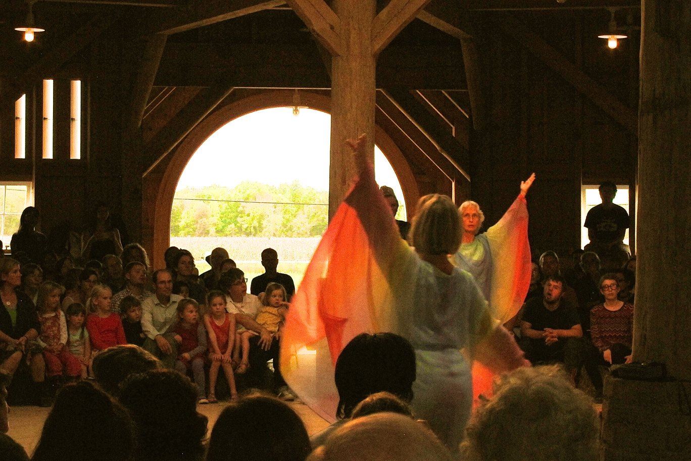 People watching a dance performance inside a wooden barn at Triform Camphill.