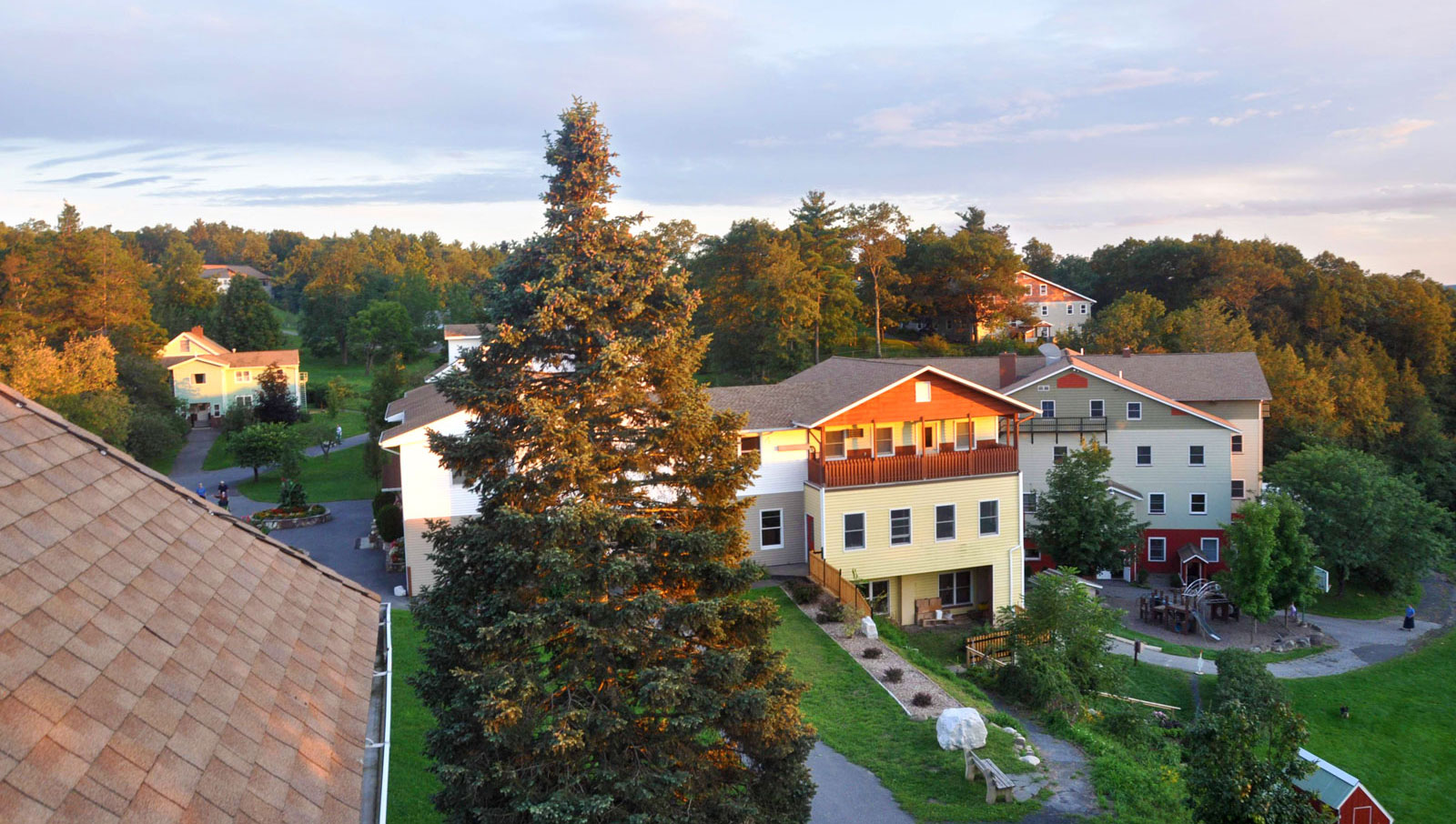 Community homes at Woodcrest Bruderhof surrounded by trees and greenery.