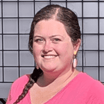 Smiling woman with braided hair in front of a grid background.