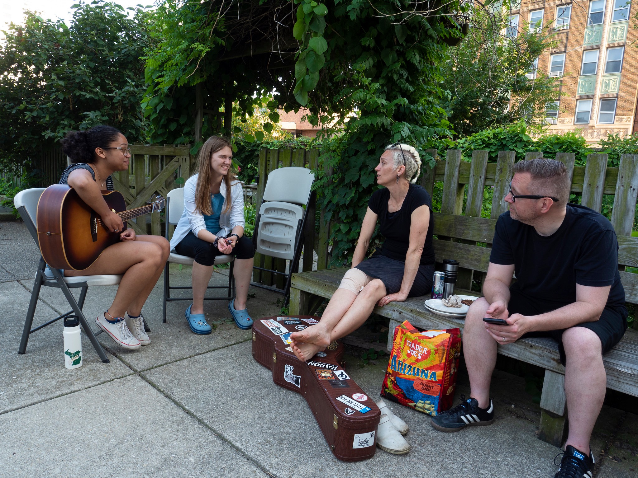 Group of diverse people enjoying music and conversation outdoors.