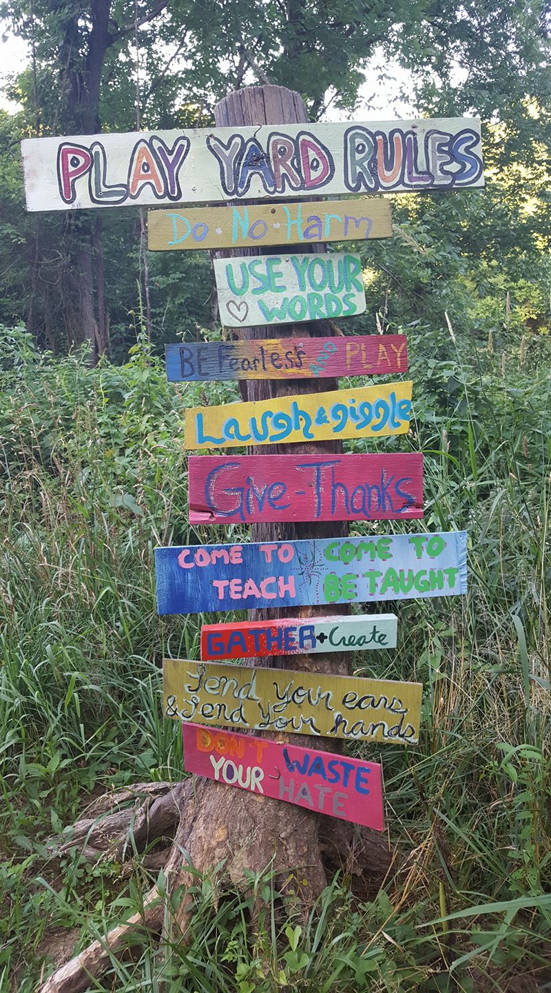 Colorful handmade sign with yard rules at Sage Valley Ecovillage.