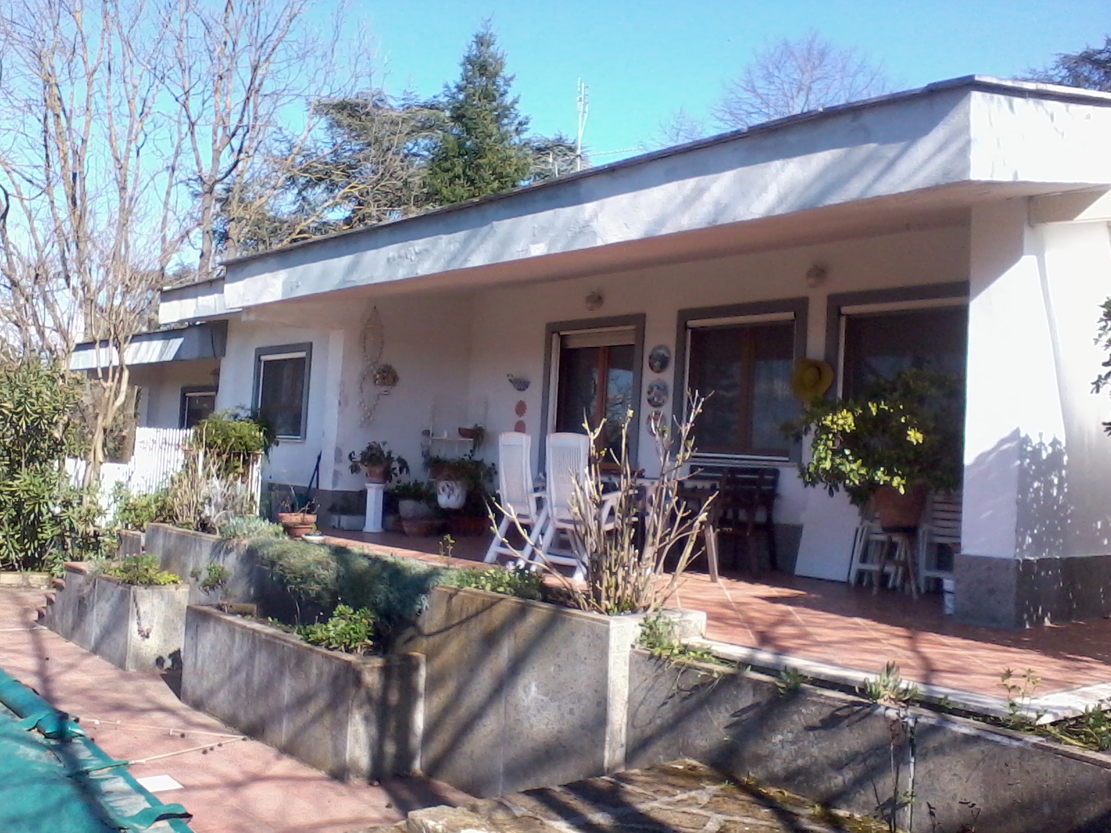 Exterior view of a community house with garden and outdoor seating.