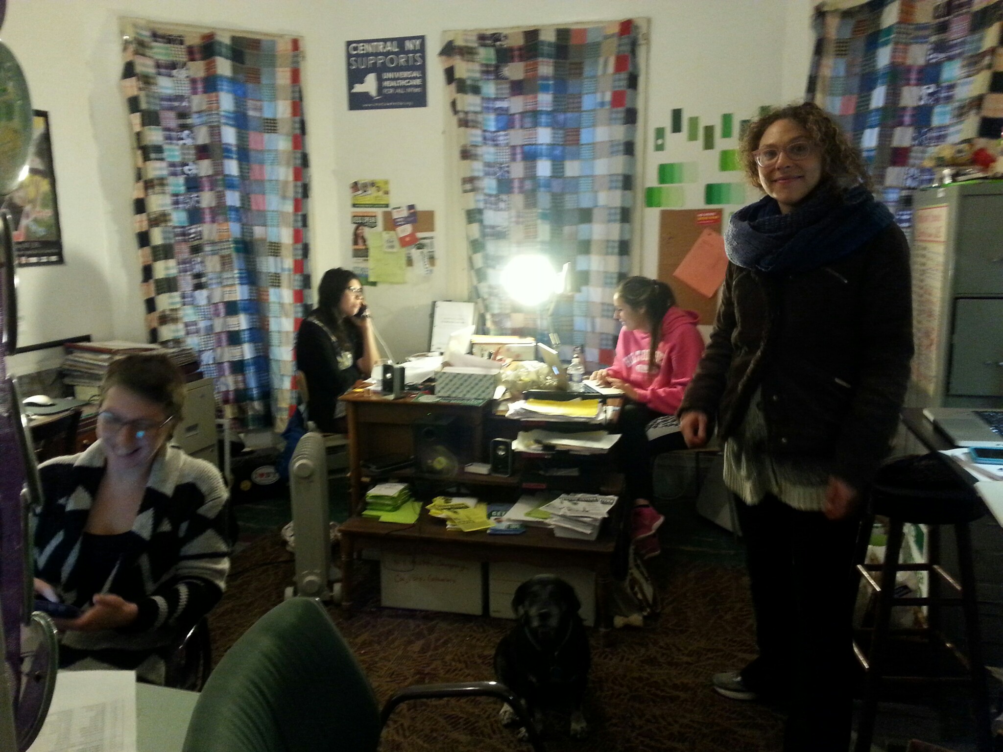 People working in a community space with colorful curtains and bookshelves.