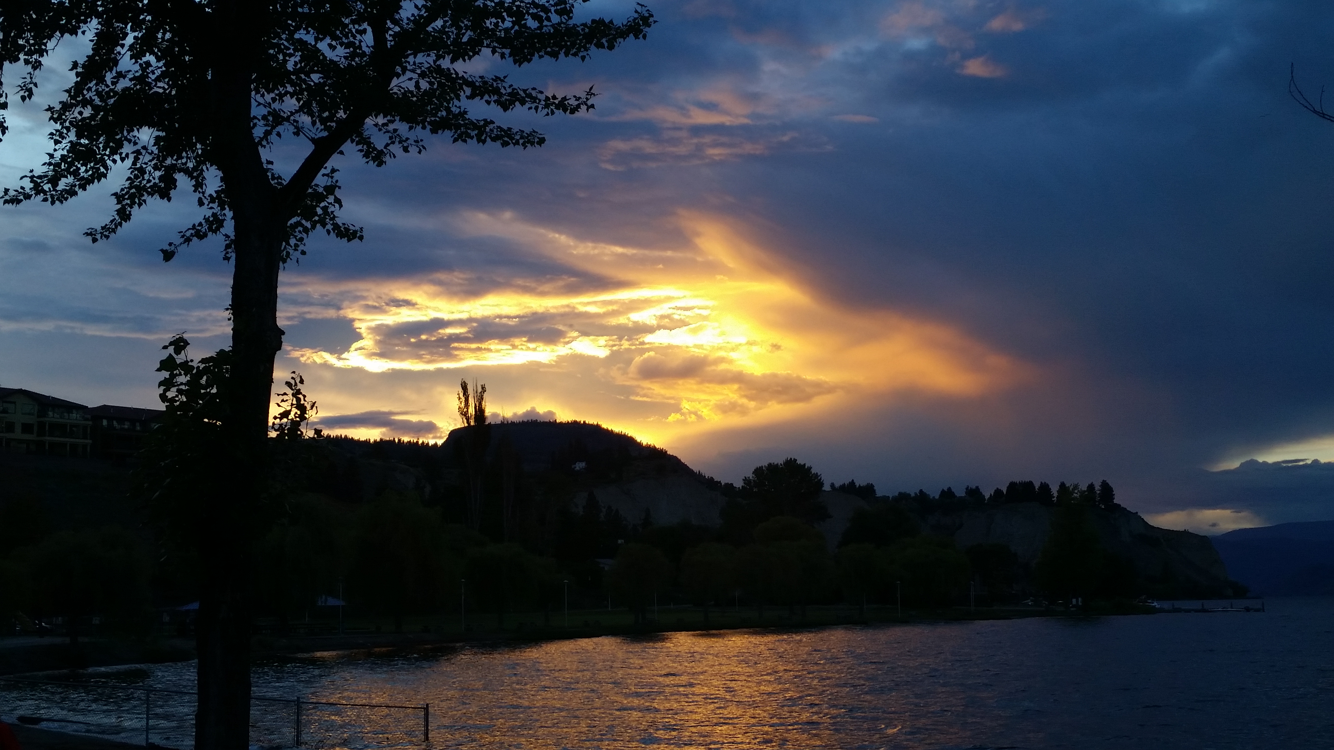 Beautiful sunset over a lake with trees and hills at Foundation for Intentional Community.