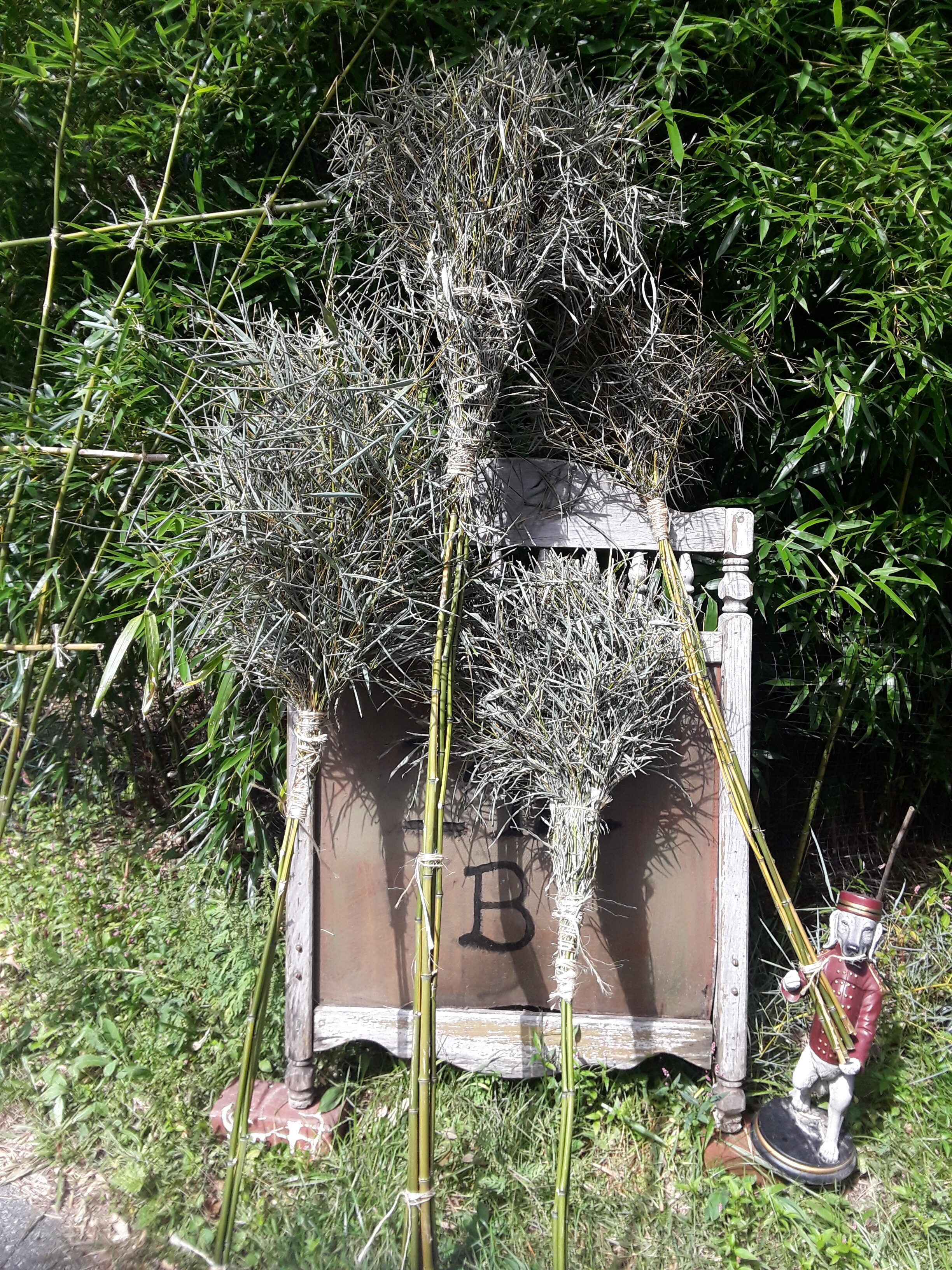 Dried ornamental plants arranged in a garden setting with a small Santa figure.