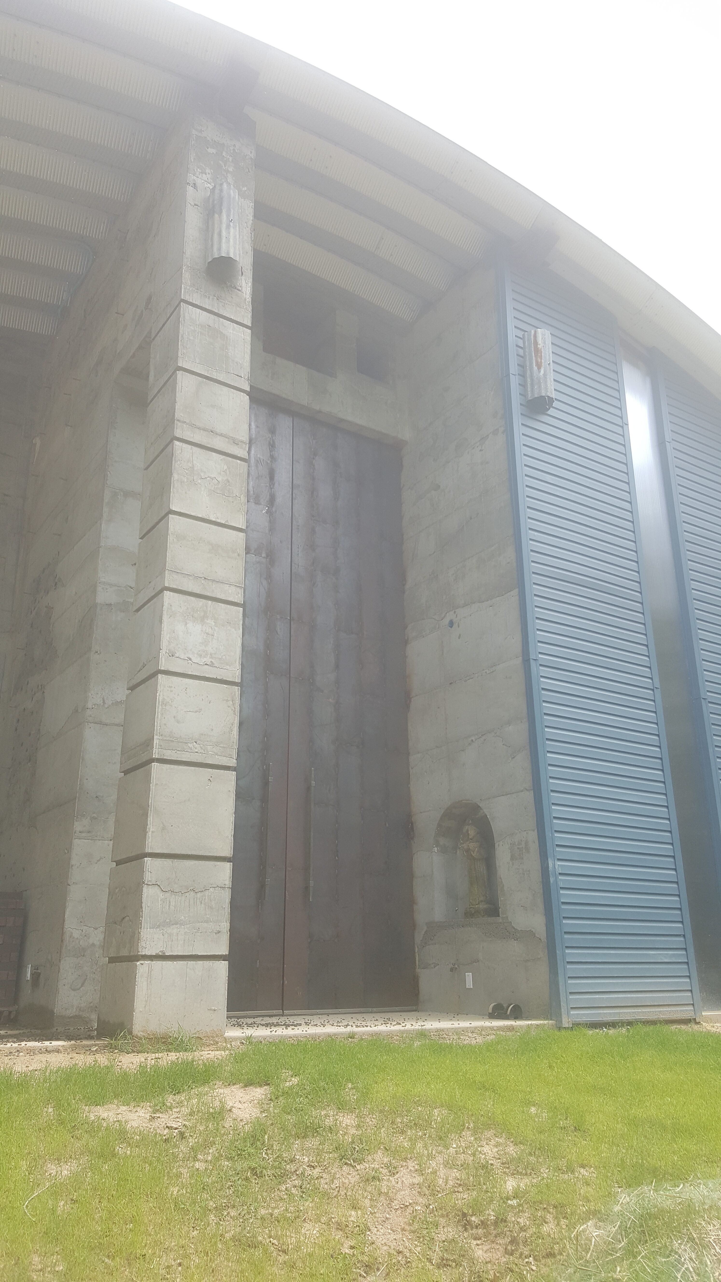 Modern community building with concrete and blue metal siding.