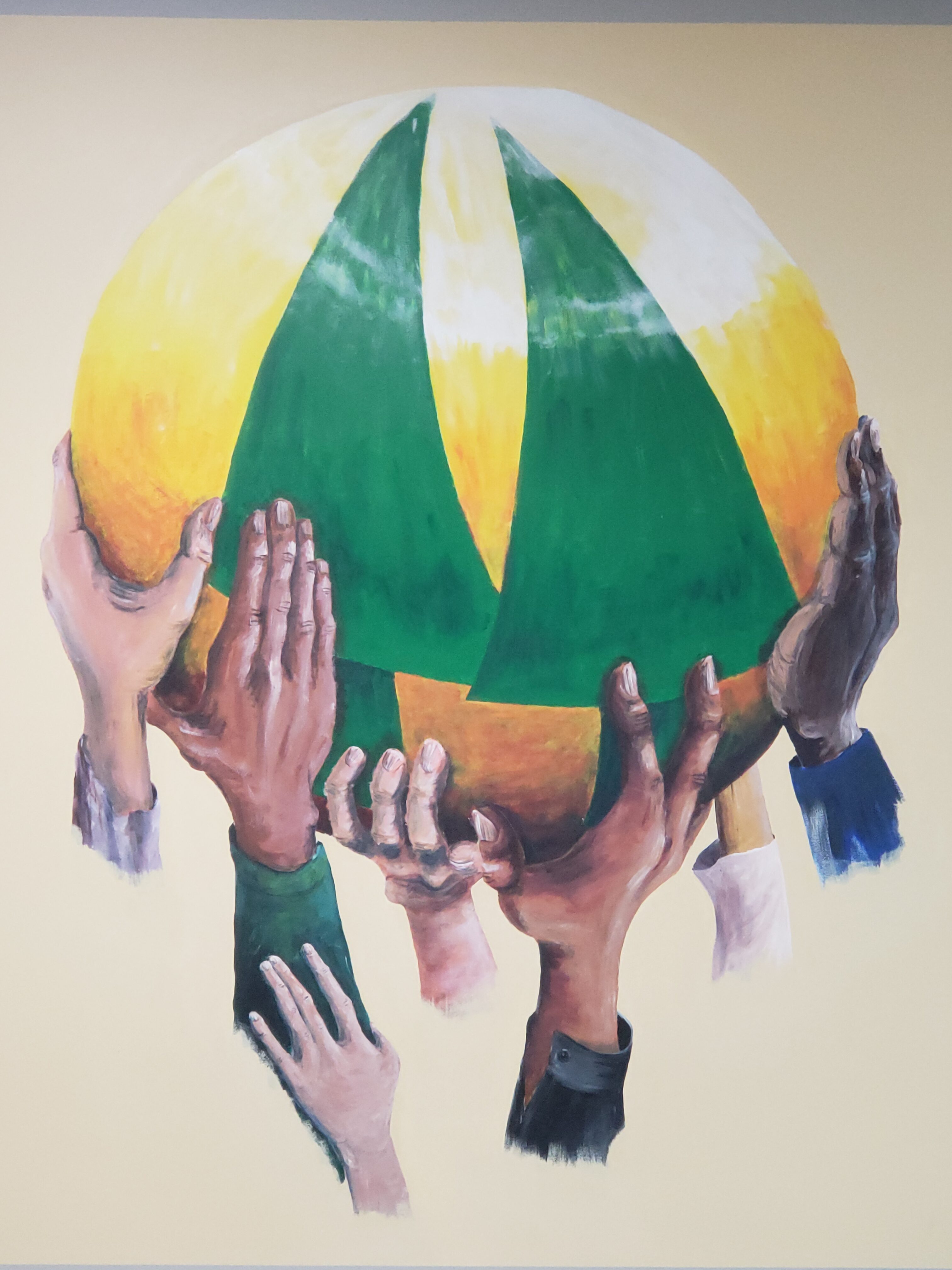 Multiple hands holding a globe with green and yellow landmasses.