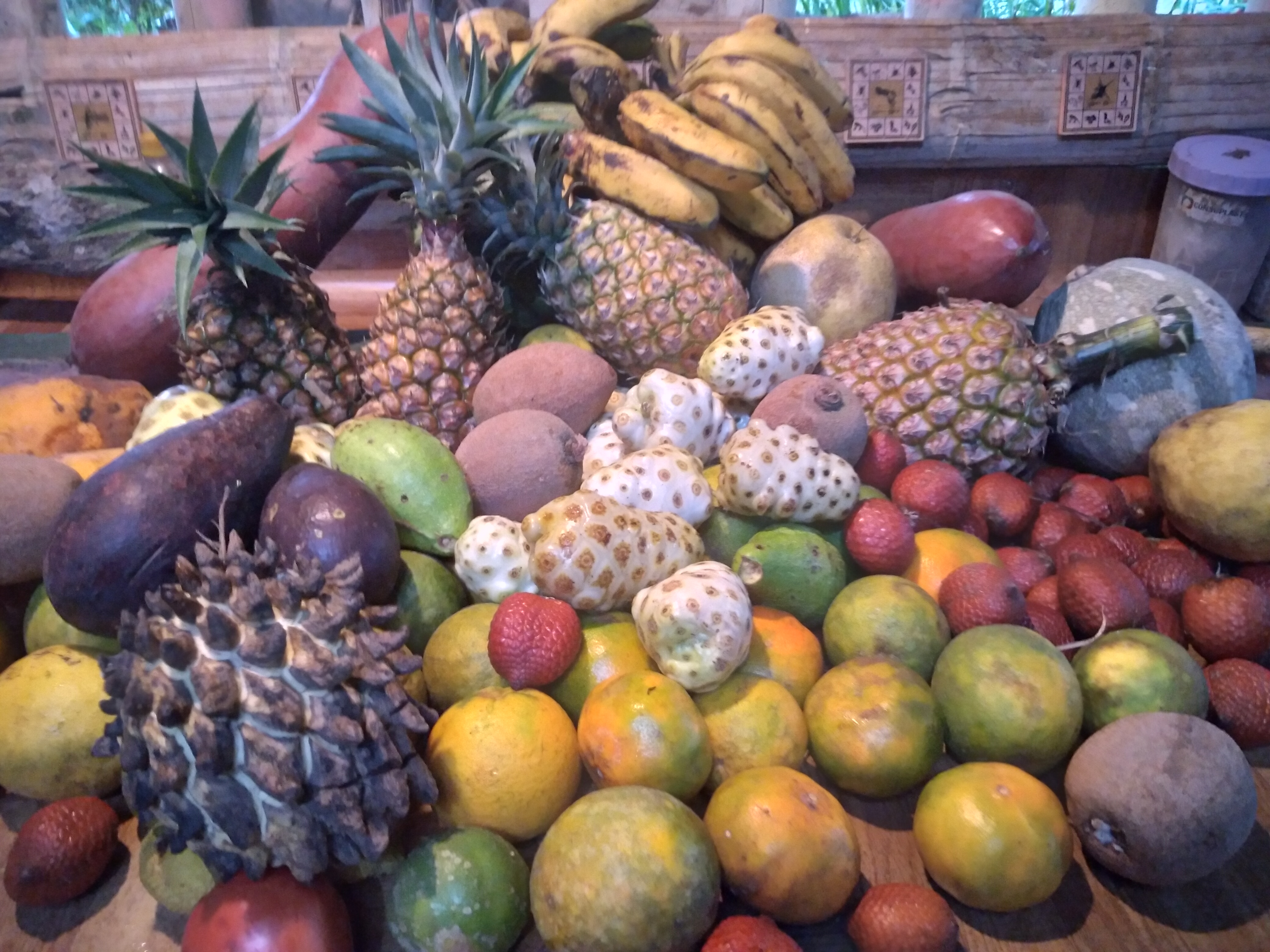 Assortment of tropical fruits including pineapples, bananas, strawberries, and mangoes.
