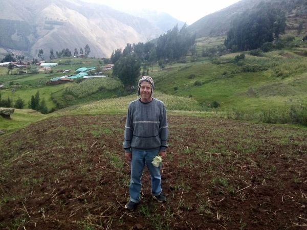 Man standing in cultivated field at Ancient Apus Ecovillage.