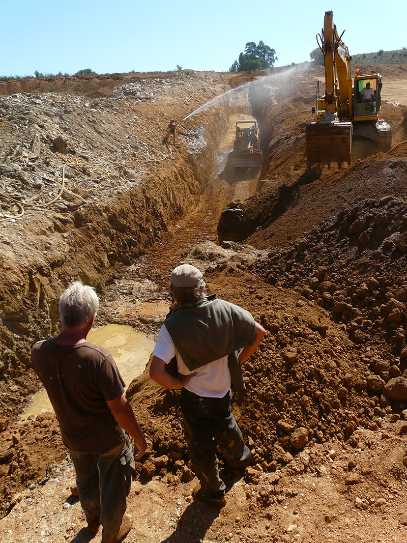 Workers and excavators at a construction site in Tamera Healing Biotope.