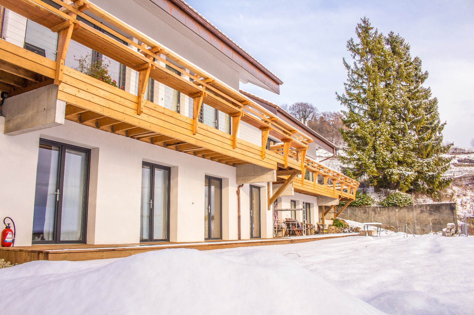 Contemporary community building with wooden balcony in snowy environment.