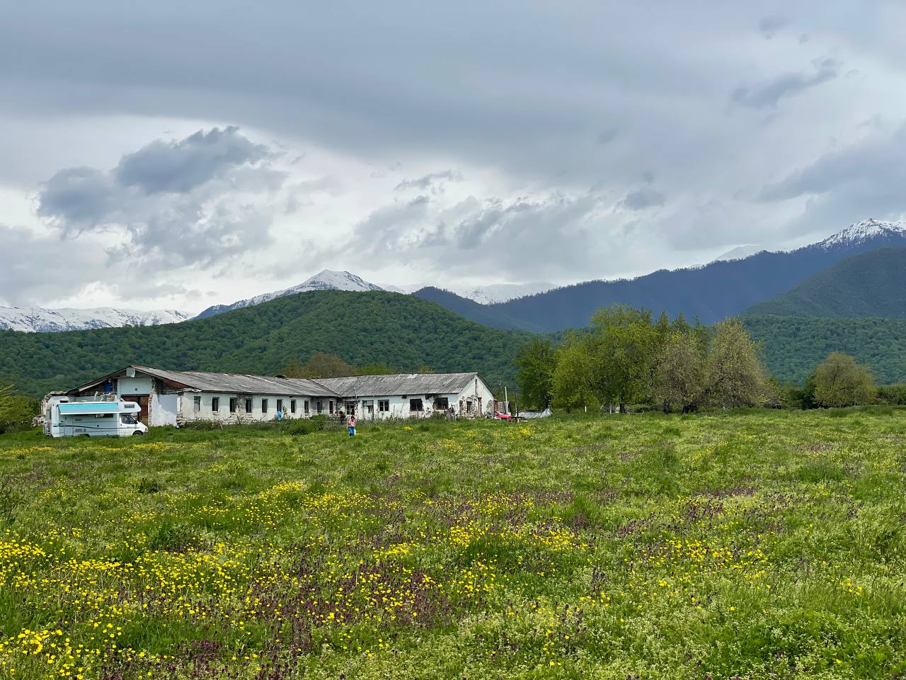 Community center in an ecovillage surrounded by mountains and greenery.
