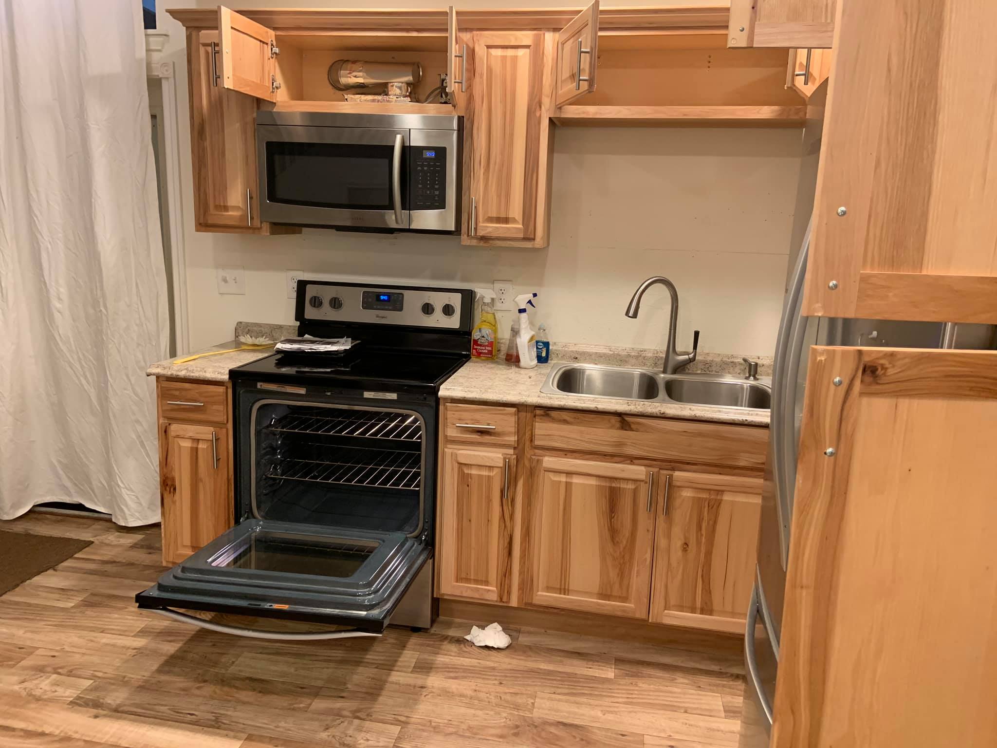 Kitchen in eco-friendly co-housing community with wooden cabinets and modern appliances.