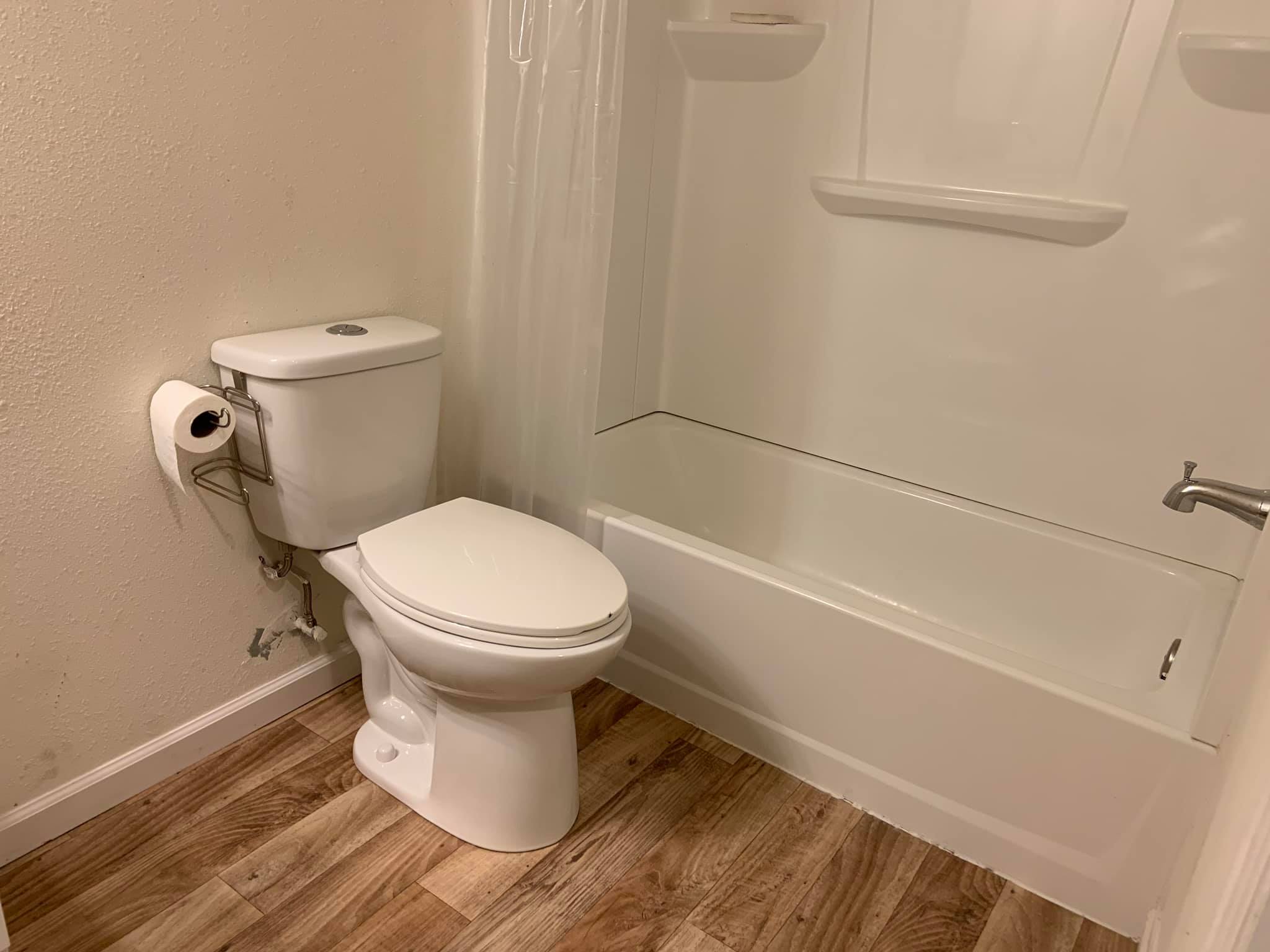 Clean bathroom with toilet and bathtub in eco-friendly community.