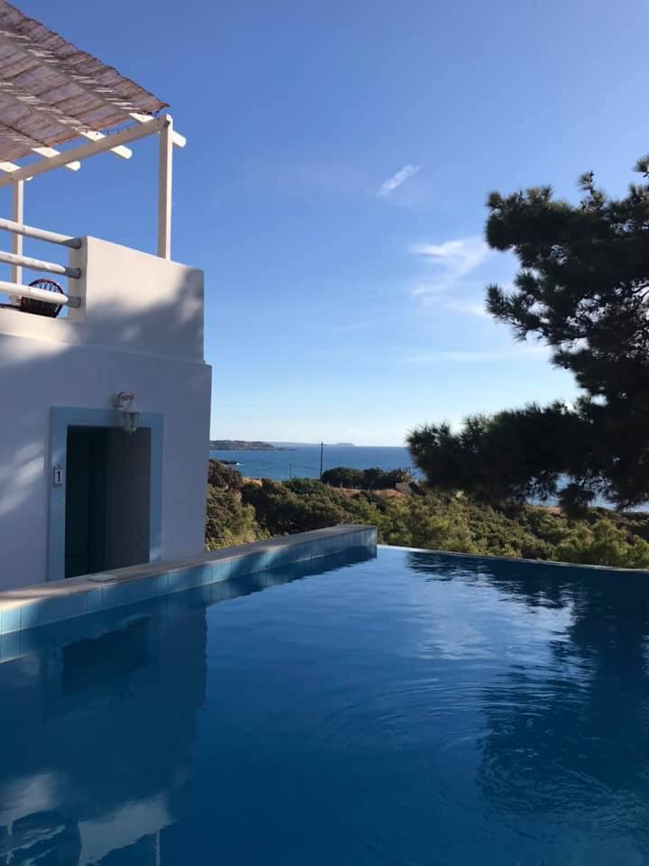Infinity pool overlooking the sea with white building and trees in Kallipoli.