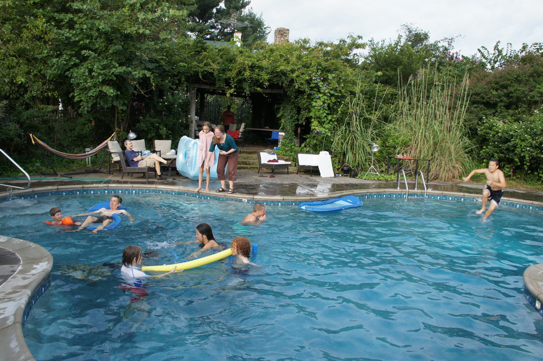 People enjoying swimming and relaxing at a community pool in Emerson Commons Cohousing.