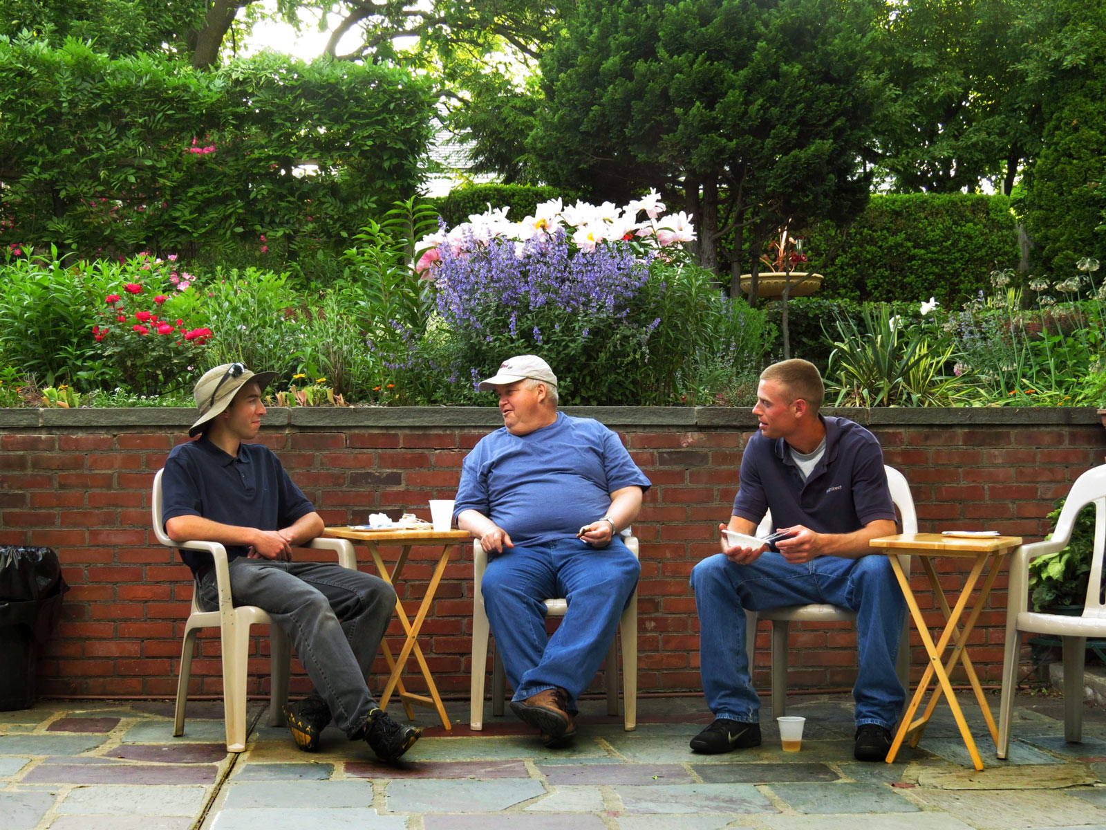 People sitting and talking in a garden at Parkview Bruderhof community.