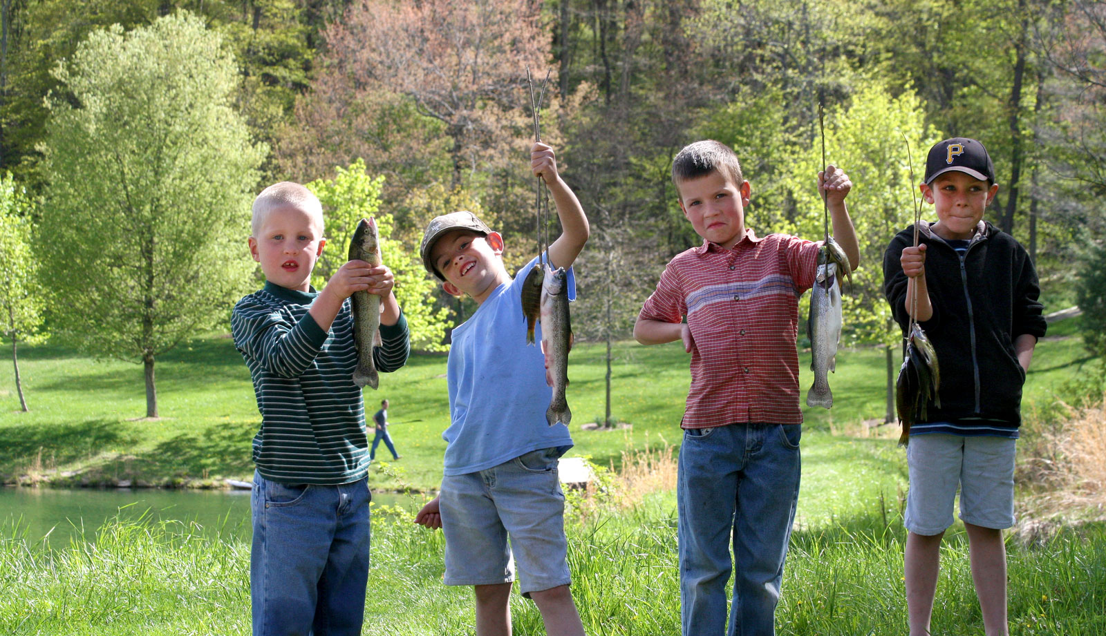Kids holding fish caught from a pond at Meadow Run Bruderhof Community.