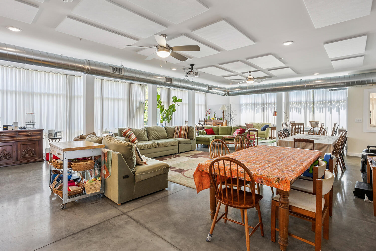 Spacious community lounge with sofas, tables, and large windows.