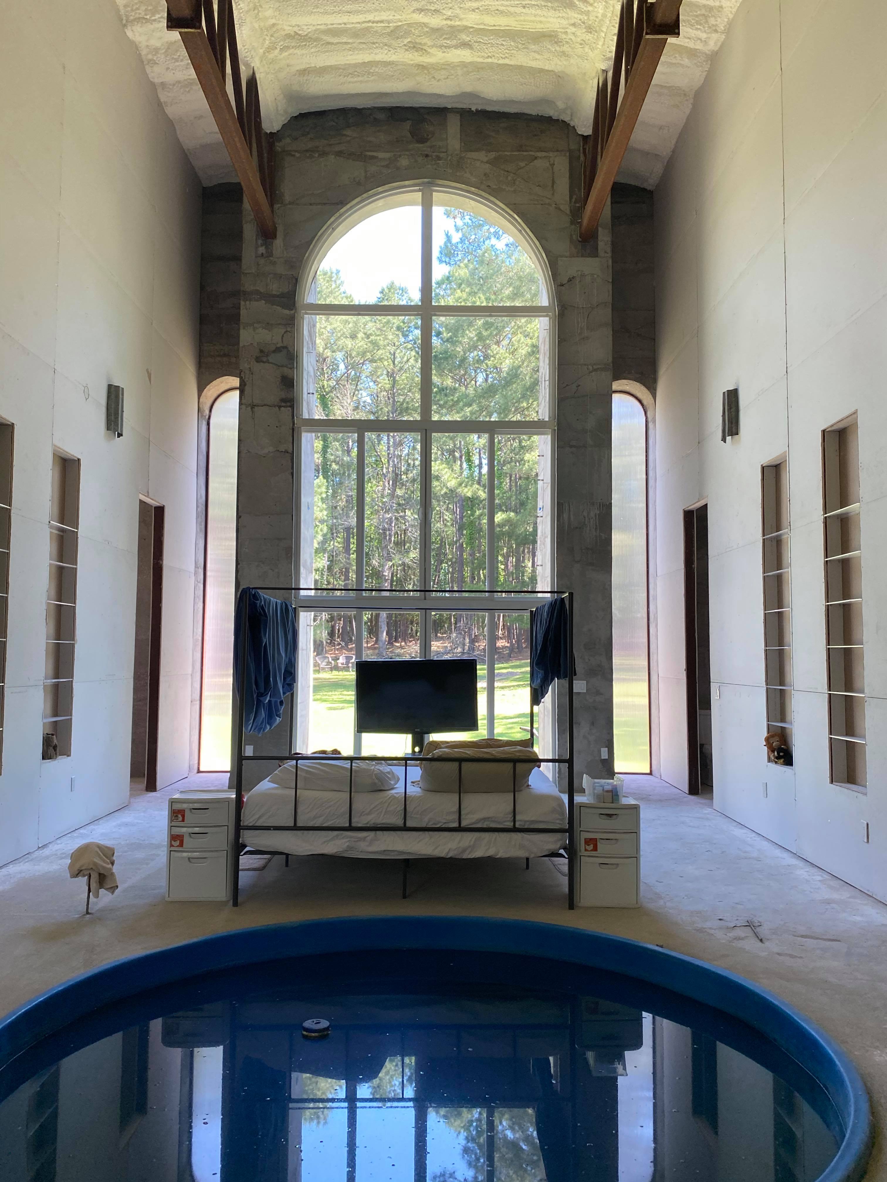 Spacious community center with large arched window and indoor pool.