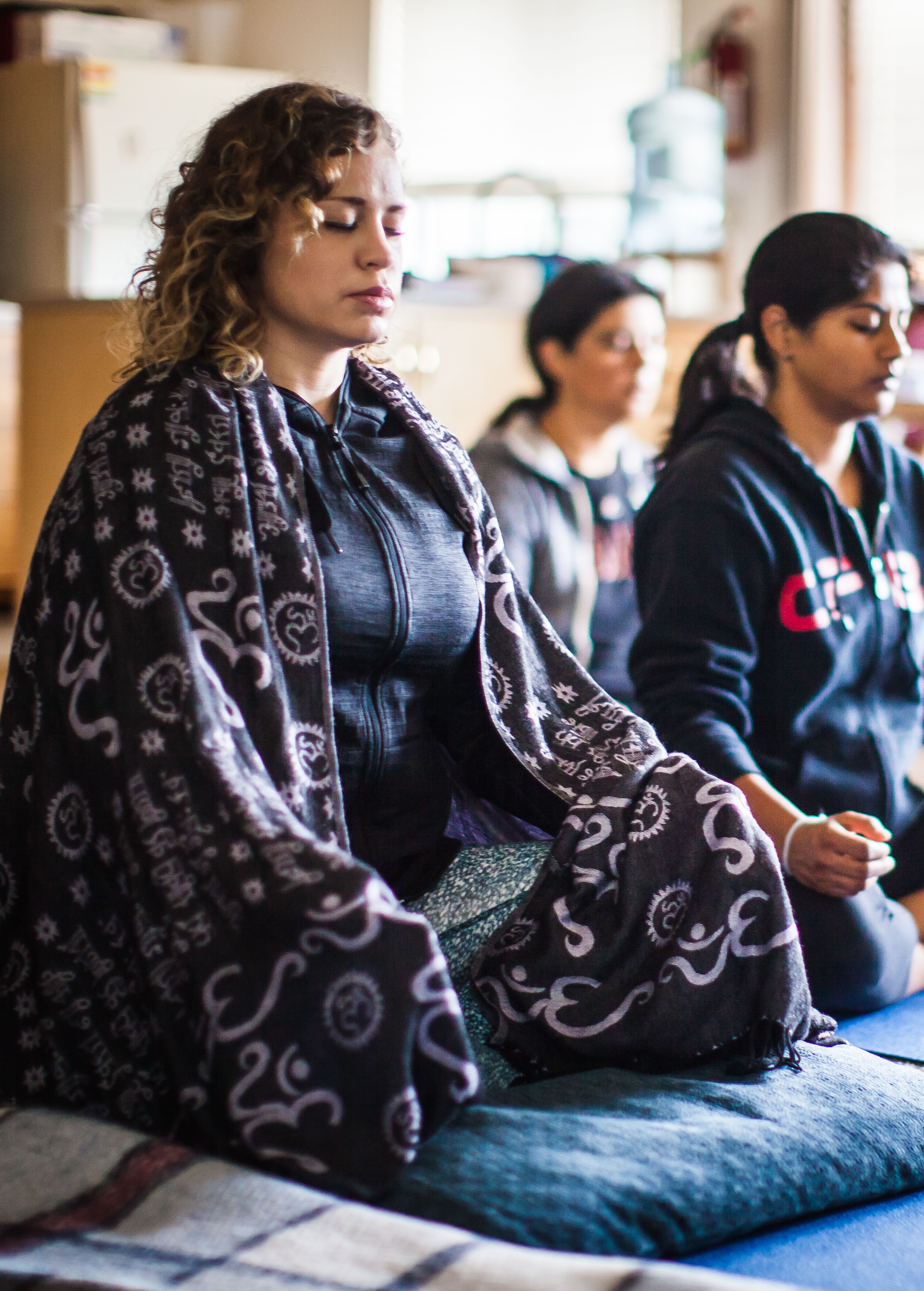 Women meditating in a peaceful indoor setting at Mount Madonna Center.