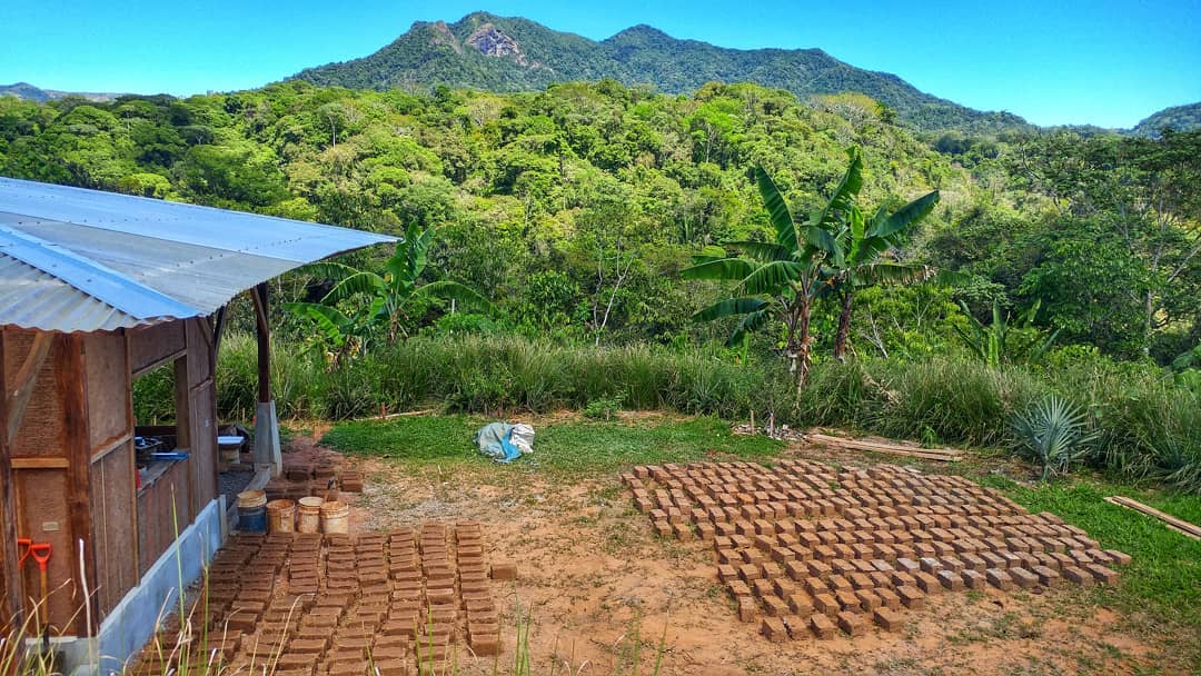 Organic brick-making process in a lush tropical setting at Rancho Mastatal.