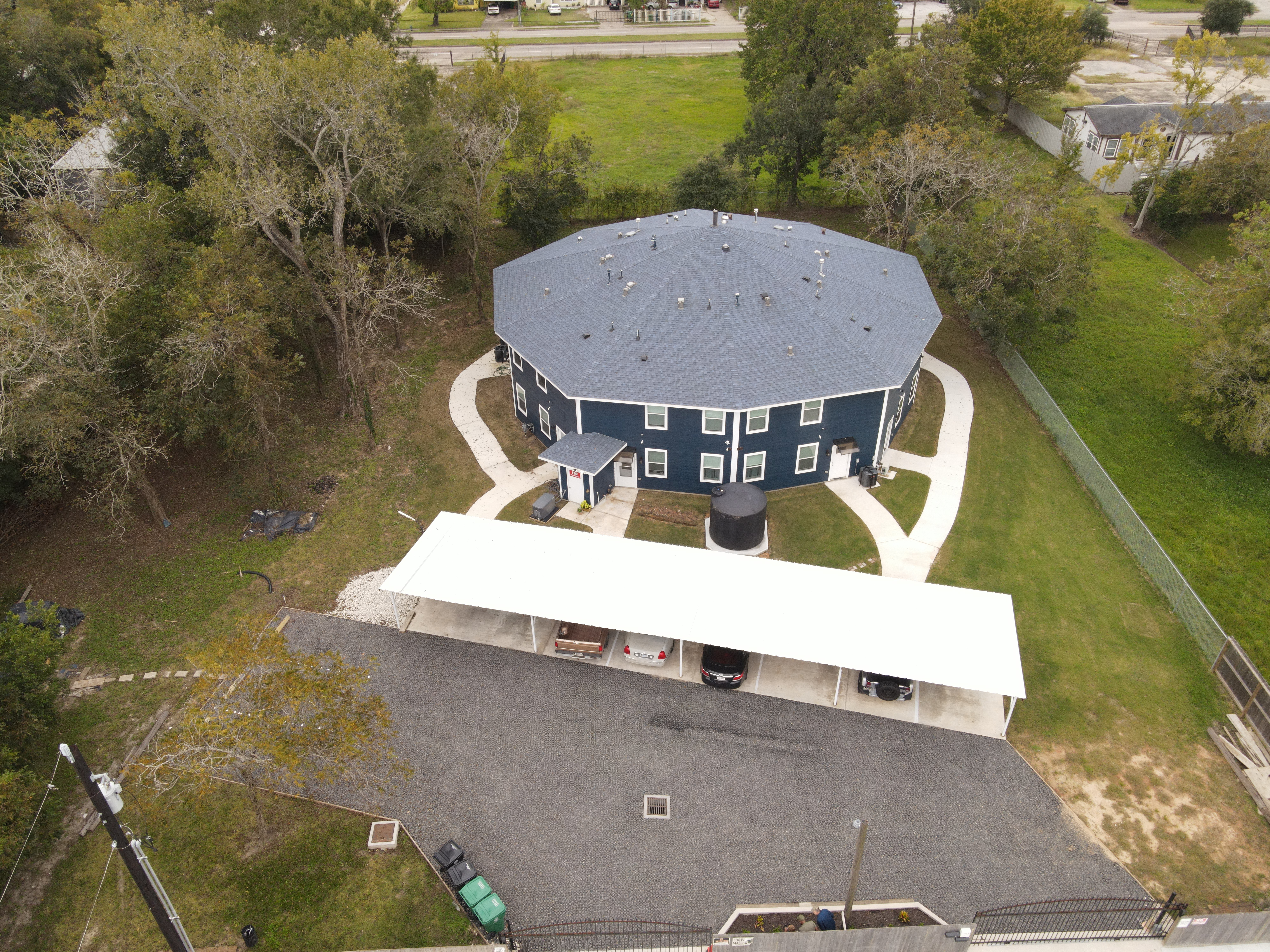 Aerial view of a round community building with parking and surrounding greenery.