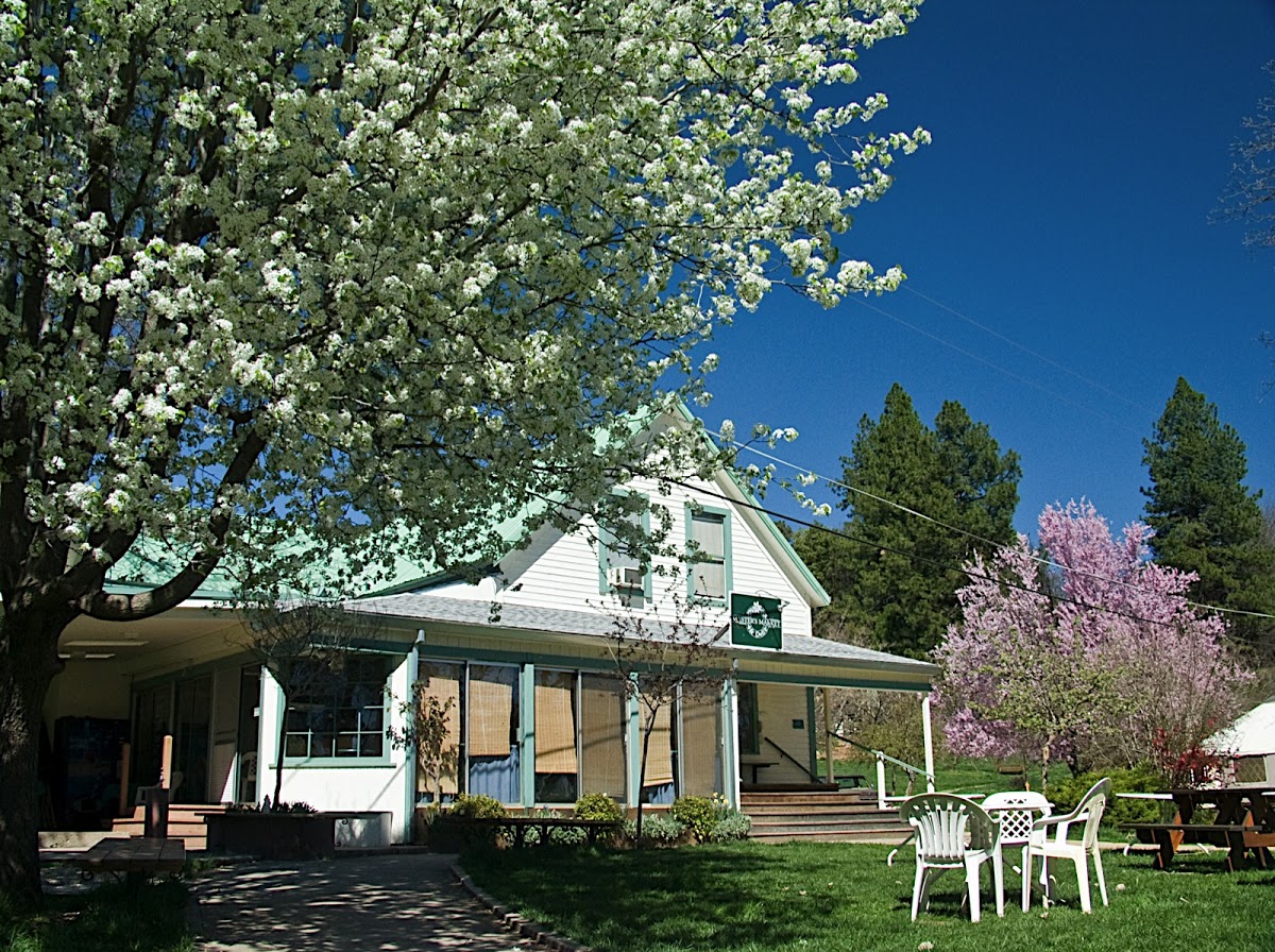Community house with blooming trees and outdoor seating at Ananda Village.