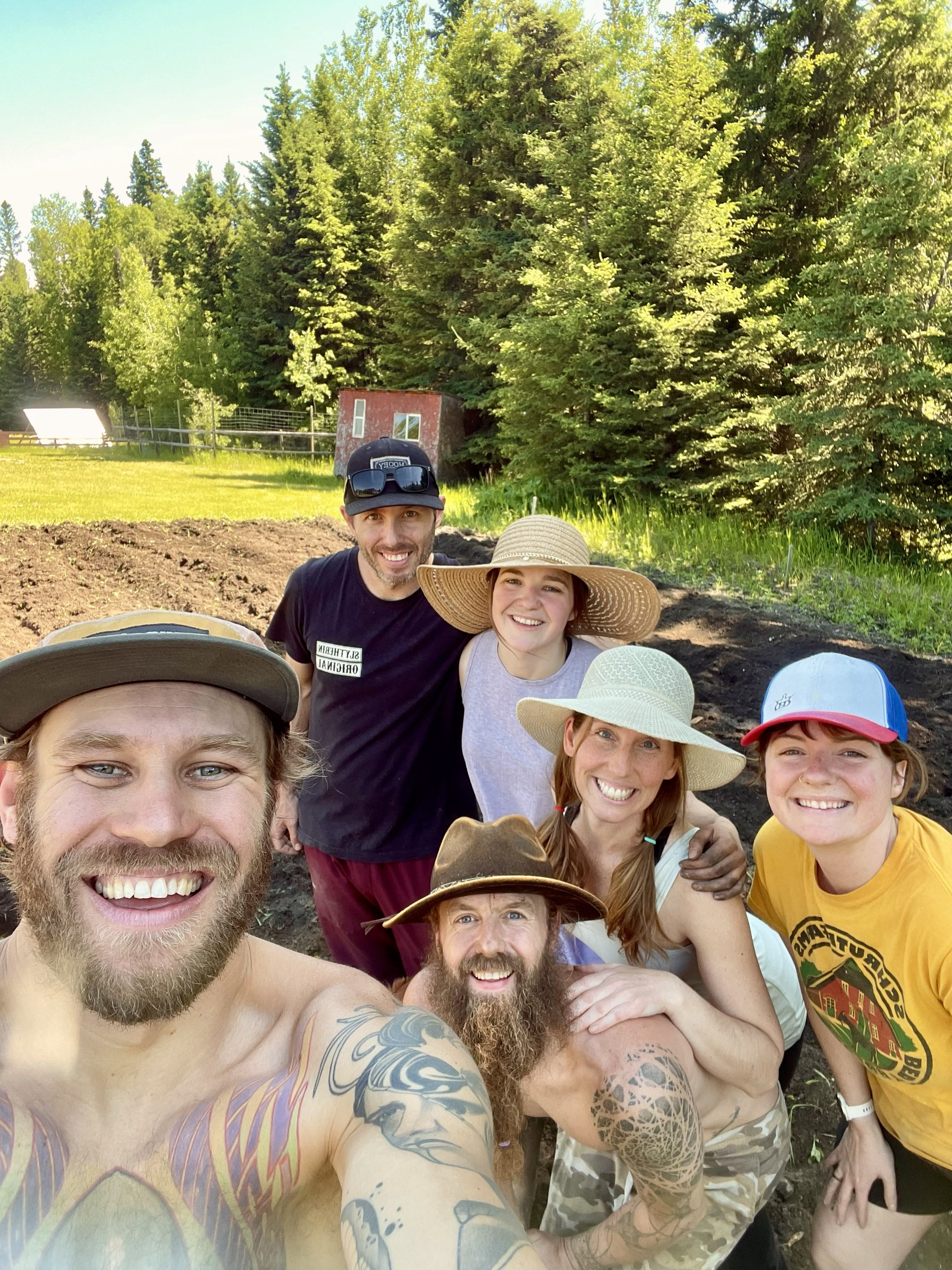 Group of people smiling outdoors at Anastara Acres community farm.
