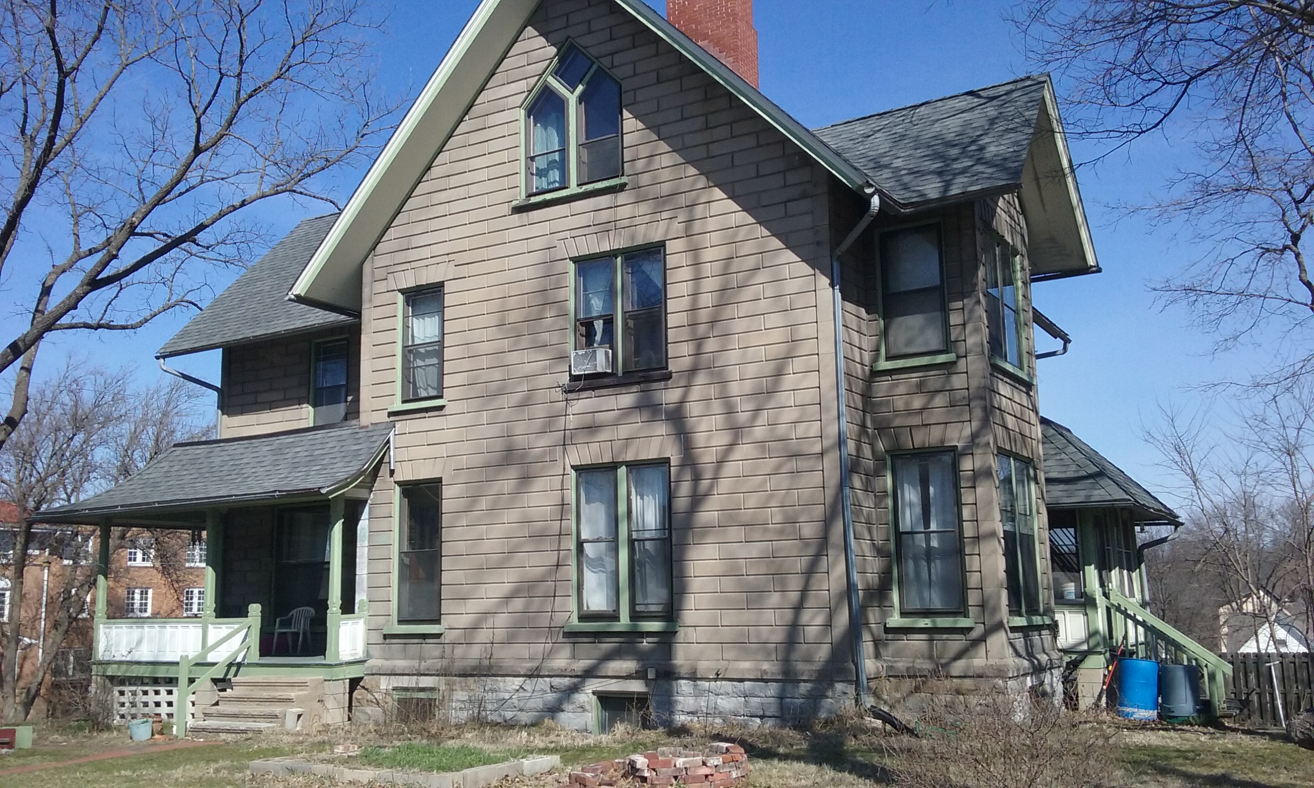 Old residential house with multiple stories and large windows.