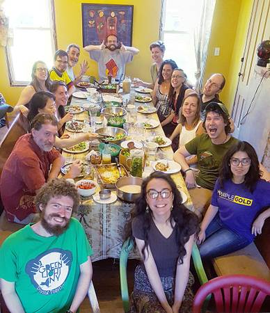 Group of diverse people enjoying a meal together at Bread and Roses Collective.