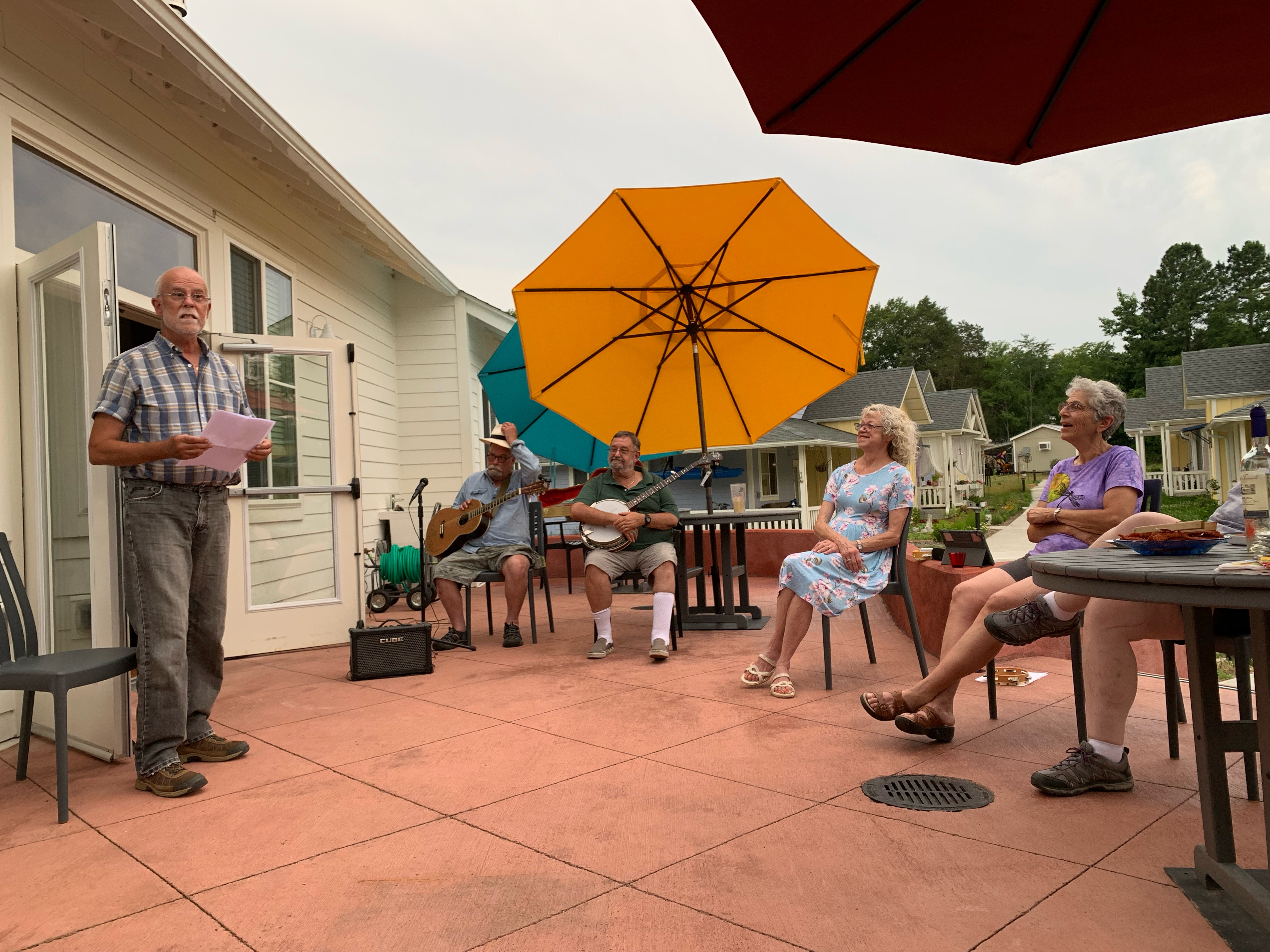 Community members enjoying music and conversation outdoors at Village Hearth Cohousing.