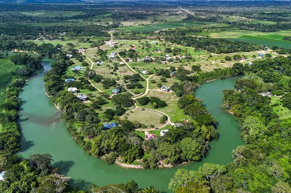Aerial view of Carmelita Gardens, Belize, with lush greenery and water bodies.