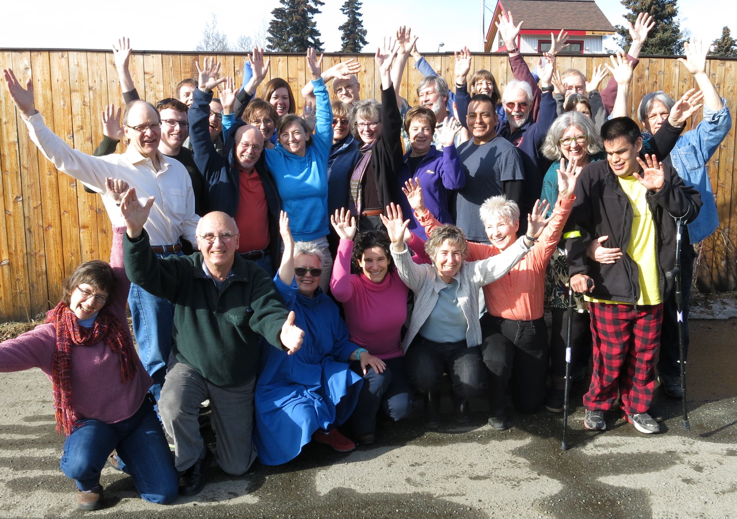 Group of diverse people celebrating outdoors at Ravens' Roost Cohousing.