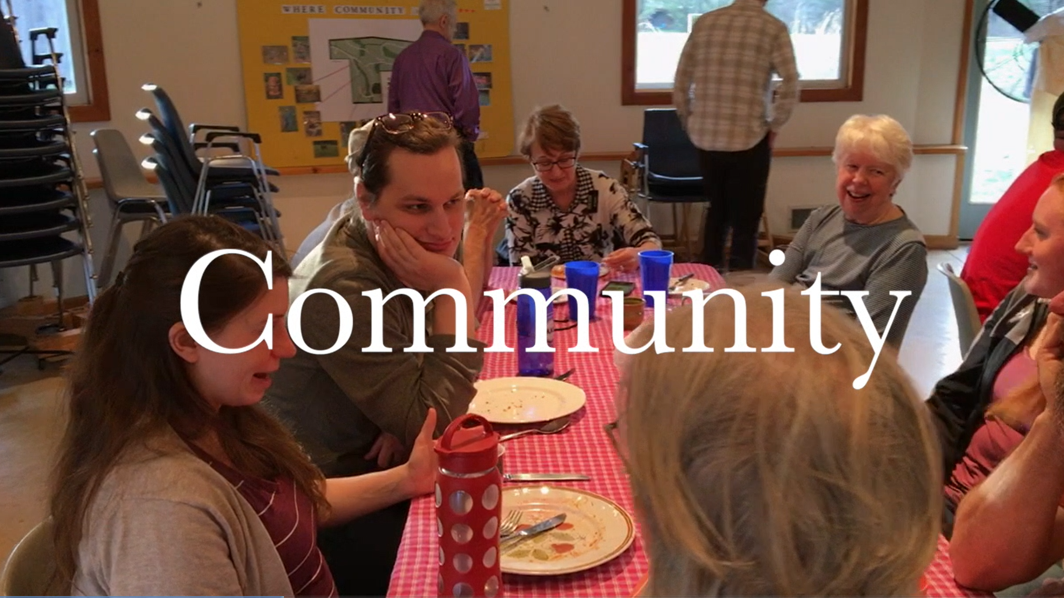 Group of people enjoying a community meal at Bryn Gweled Homesteads.