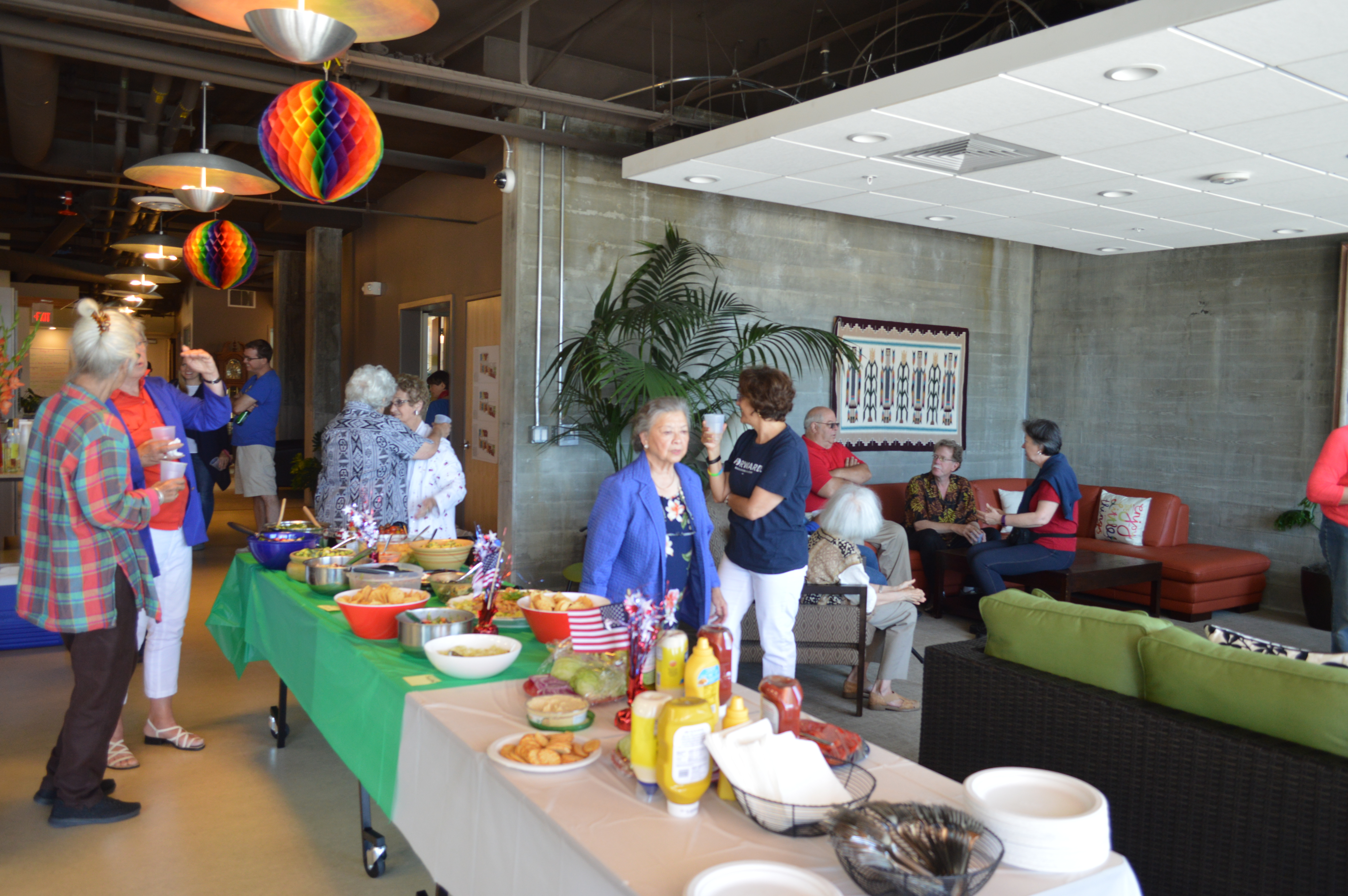 People socializing and enjoying food at Phoenix Commons community event.