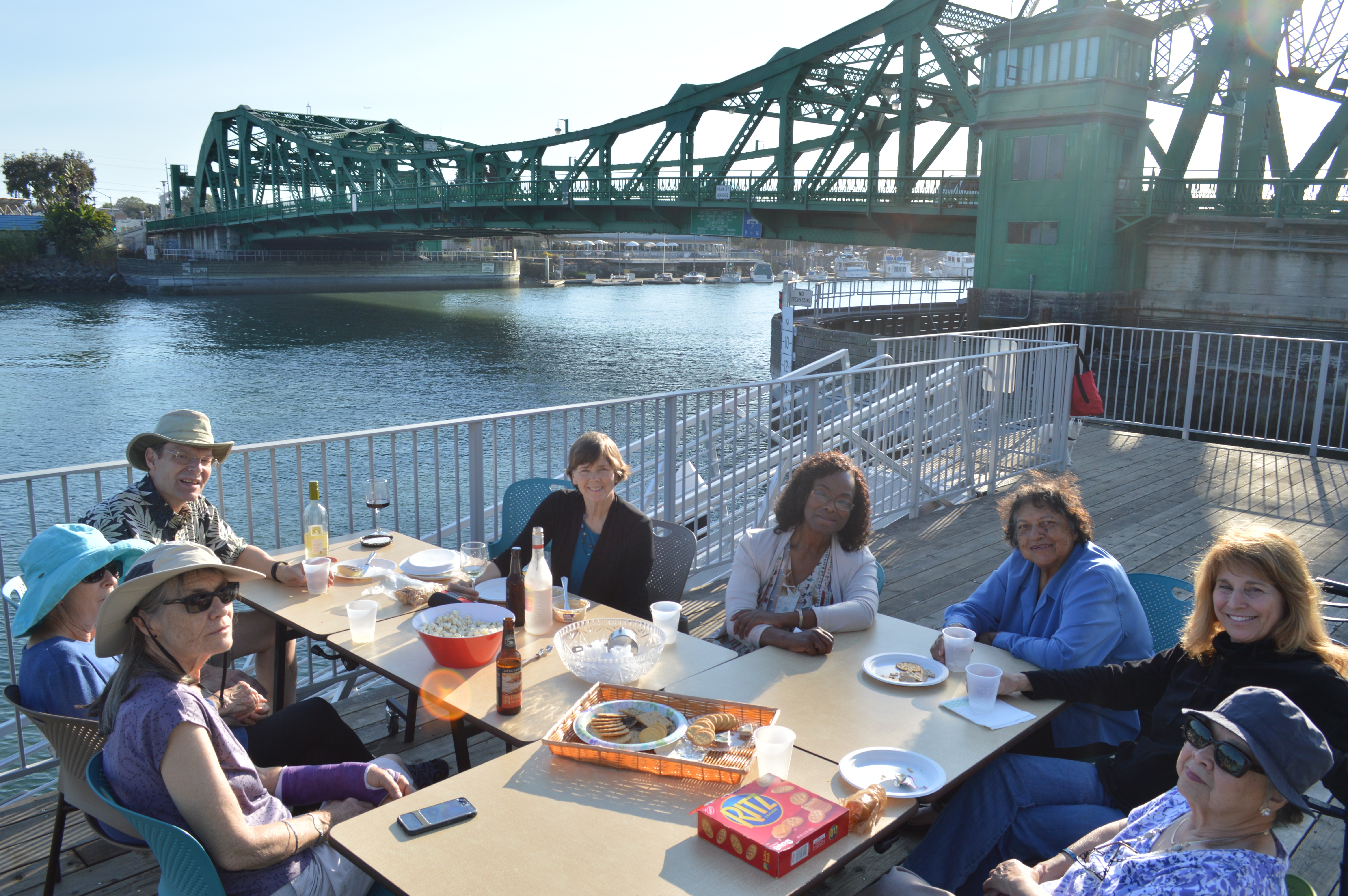 Group of people enjoying outdoor meal by the water in Oakland, CA.