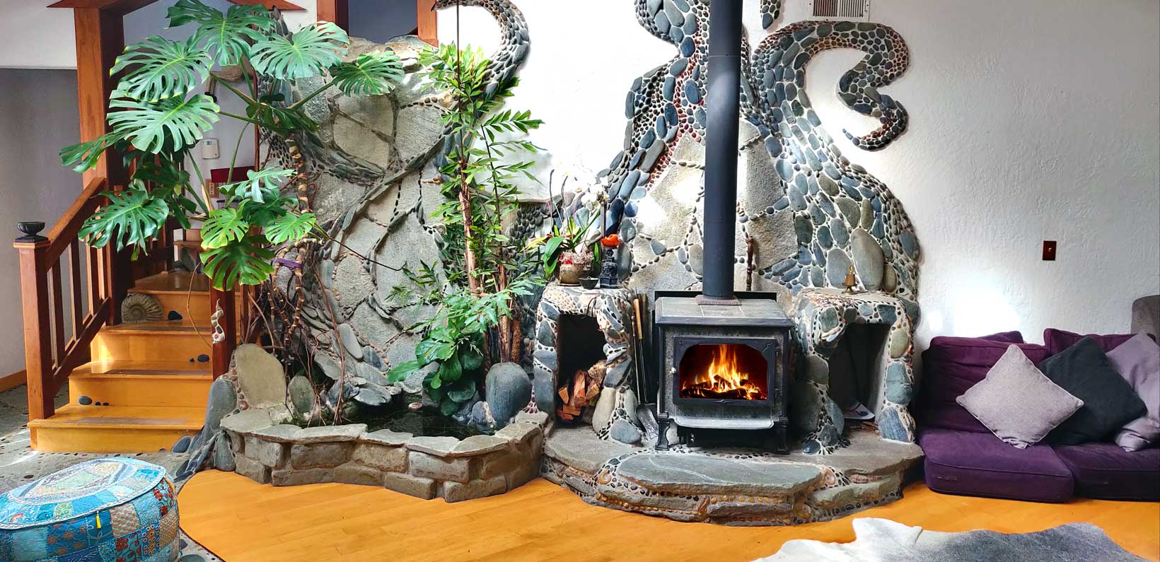 Decorative stone fireplace with a fire and artistic sculpture in a cozy living room.