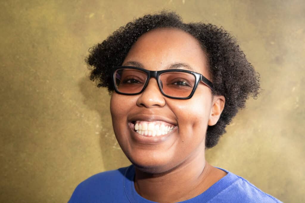 Happy woman with glasses smiling, representing community and diversity.
