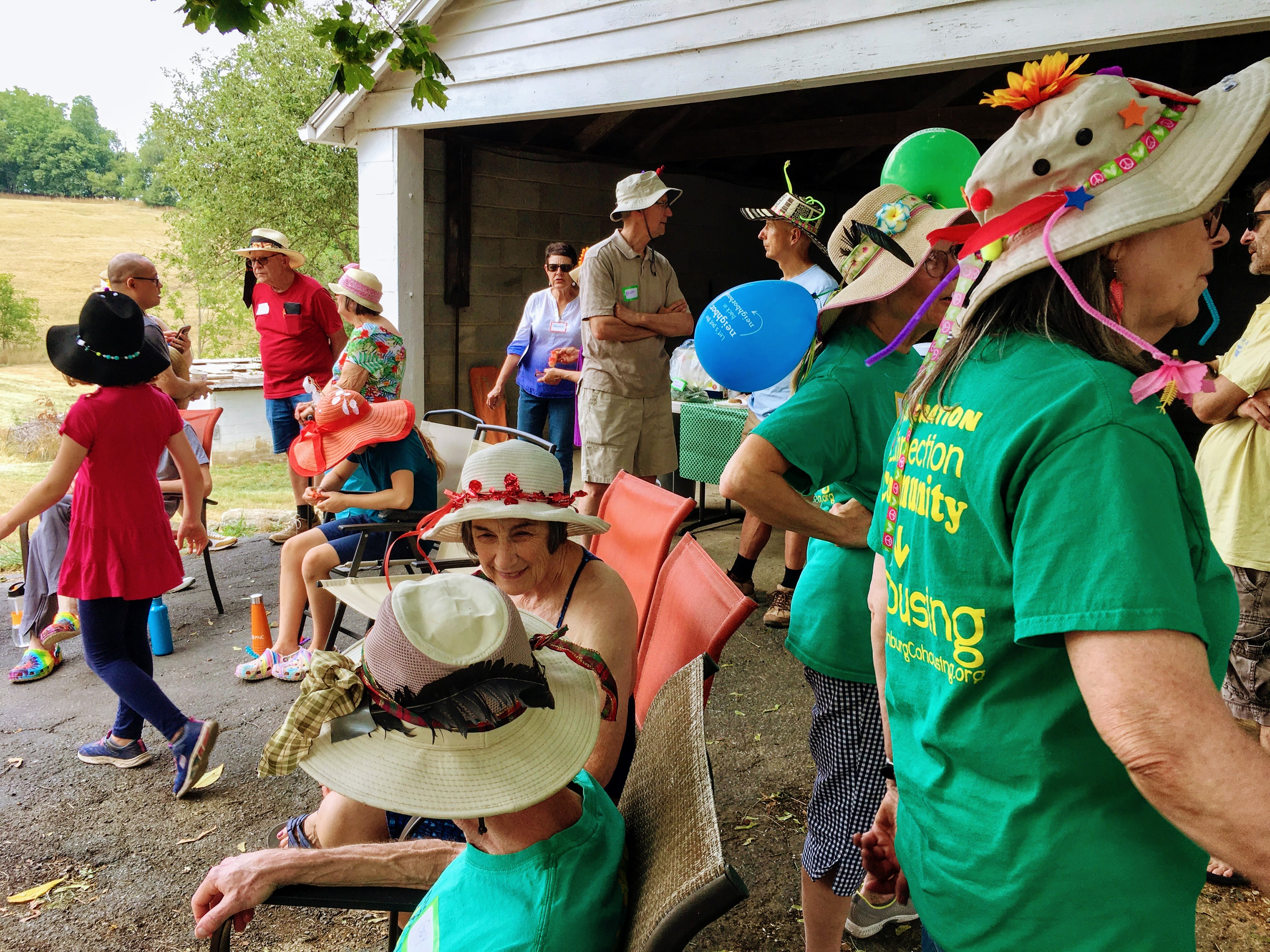 People celebrating outdoors with hats and balloons at Juniper Hill Commons.