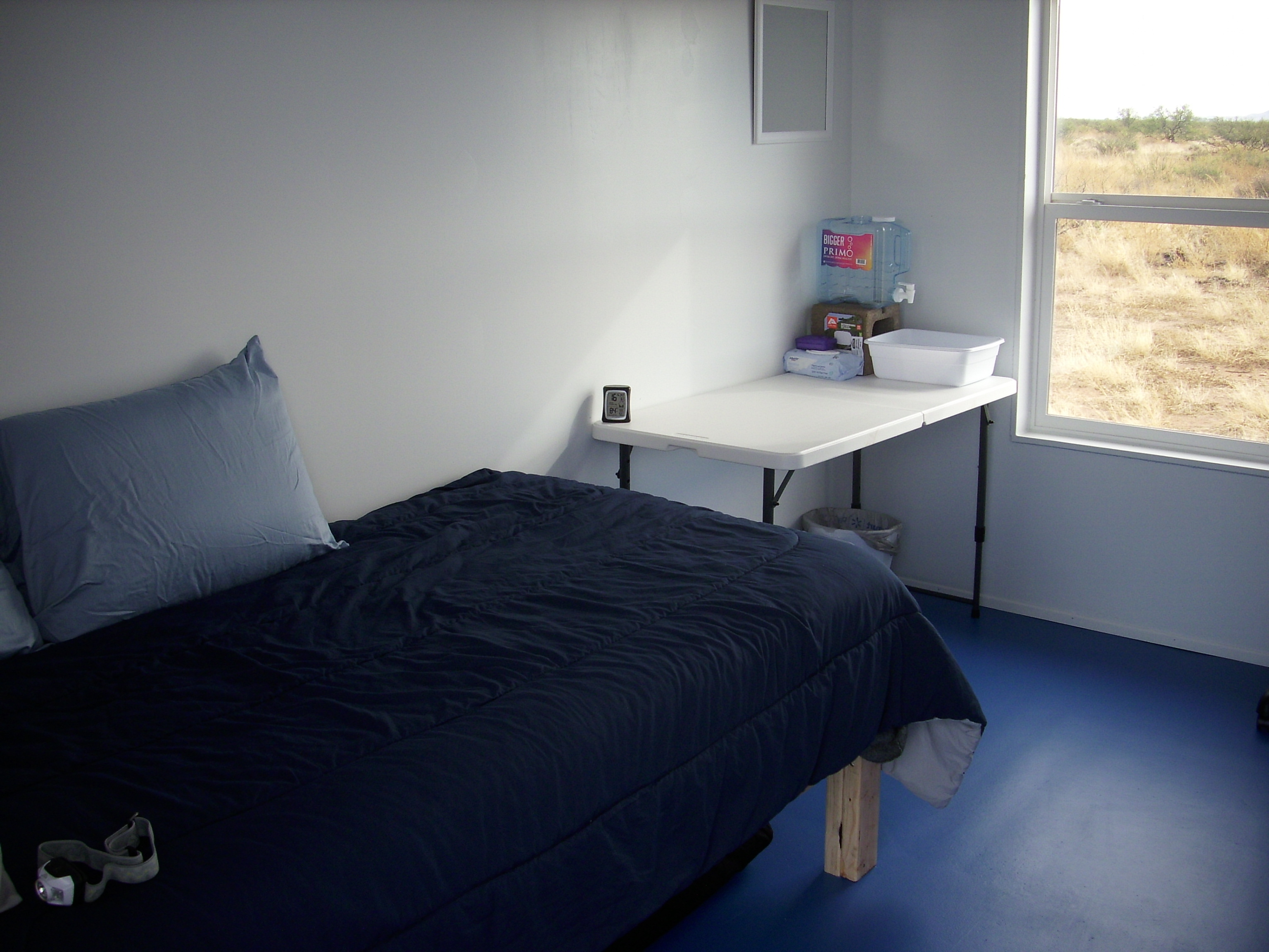 Simple solo retreat room with bed and window at Foundation for Intentional Community.
