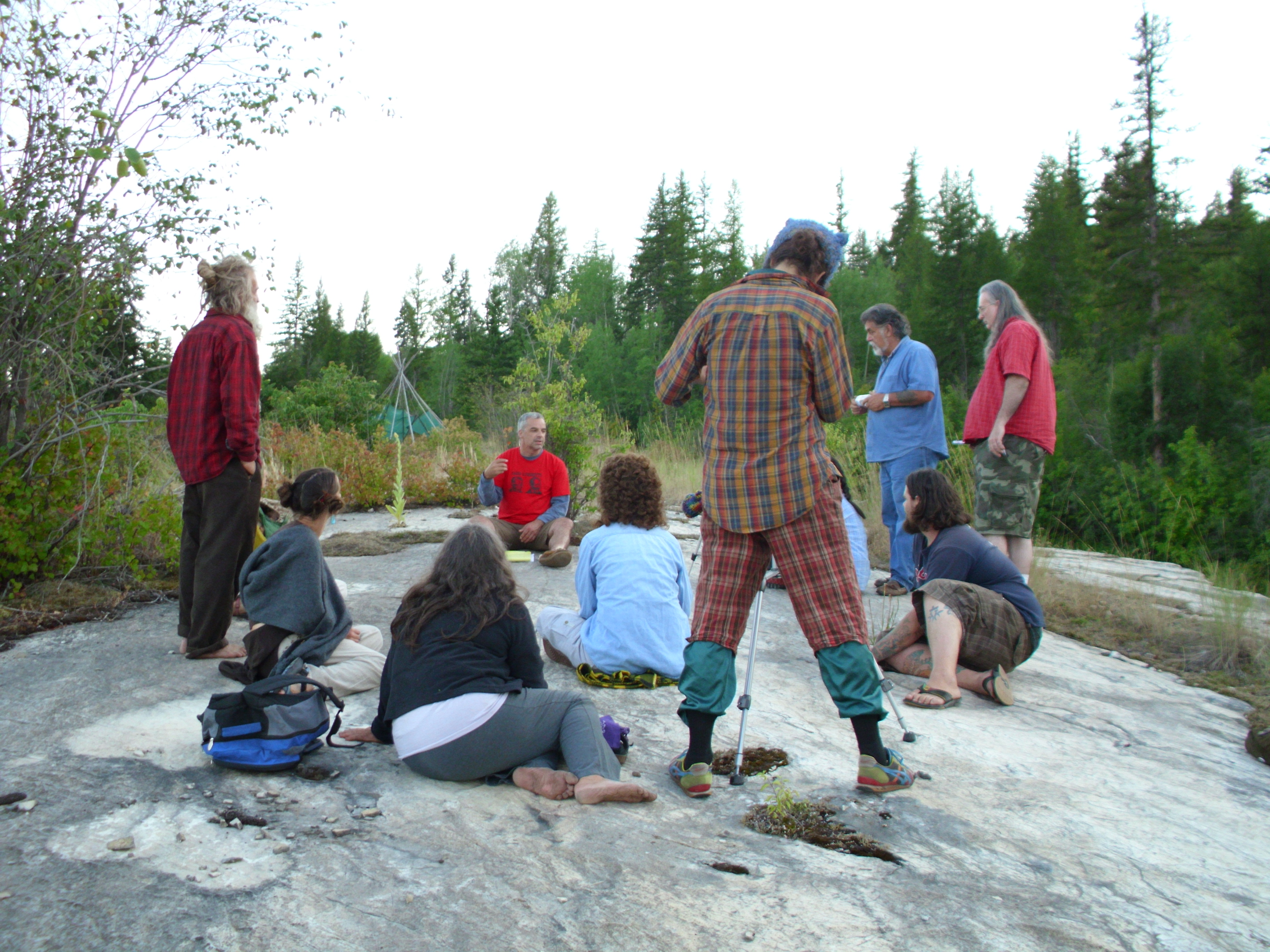 Group of people gathered outdoors in a natural setting for a community event.