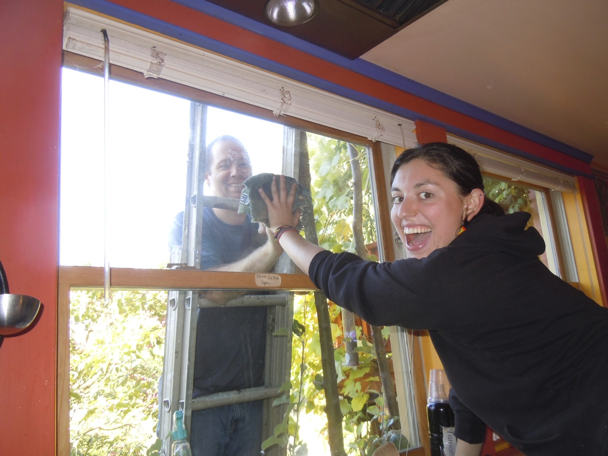 People cleaning a window at Foundation for Intentional Community event.